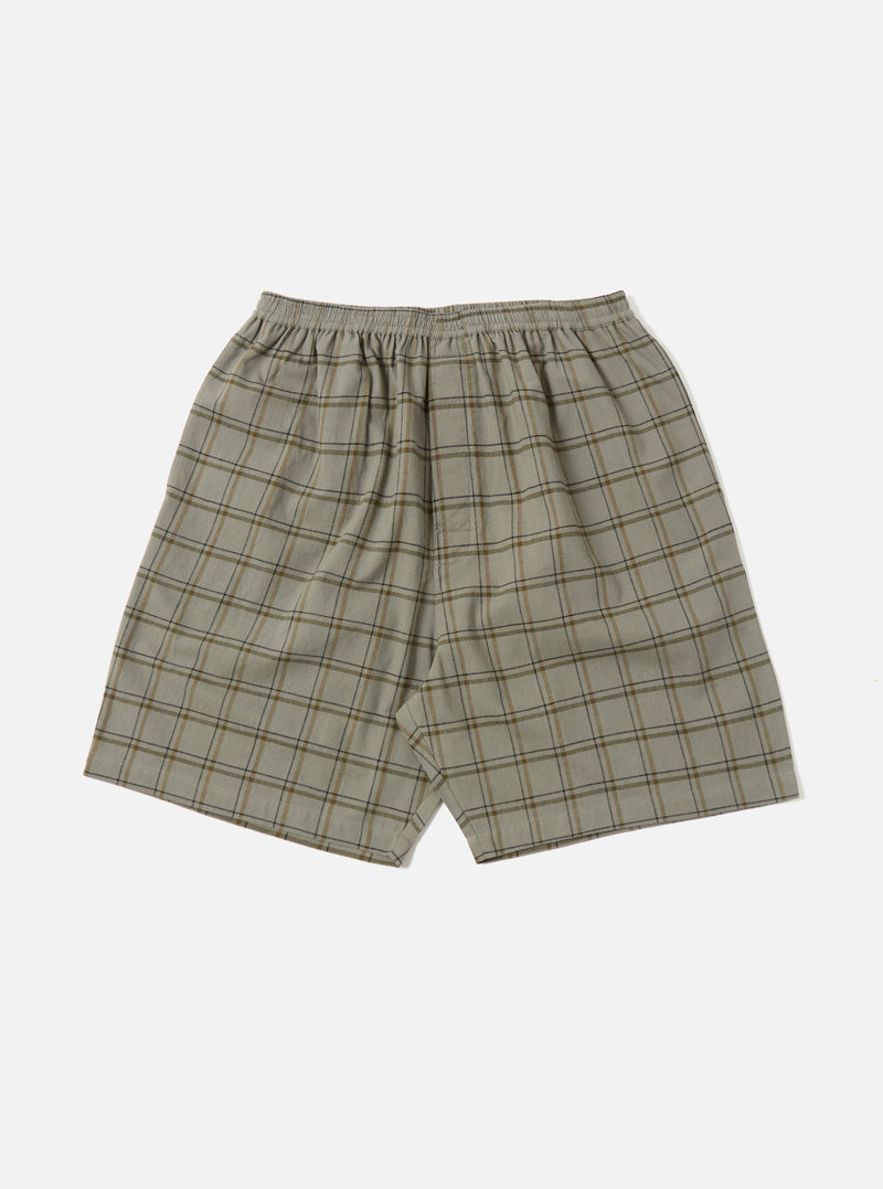 The Green PJ Plaid Pyjama Short, in a soft green and brown plaid pattern, is laid flat on a white background. The shorts have an elastic waist and a relaxed fit.