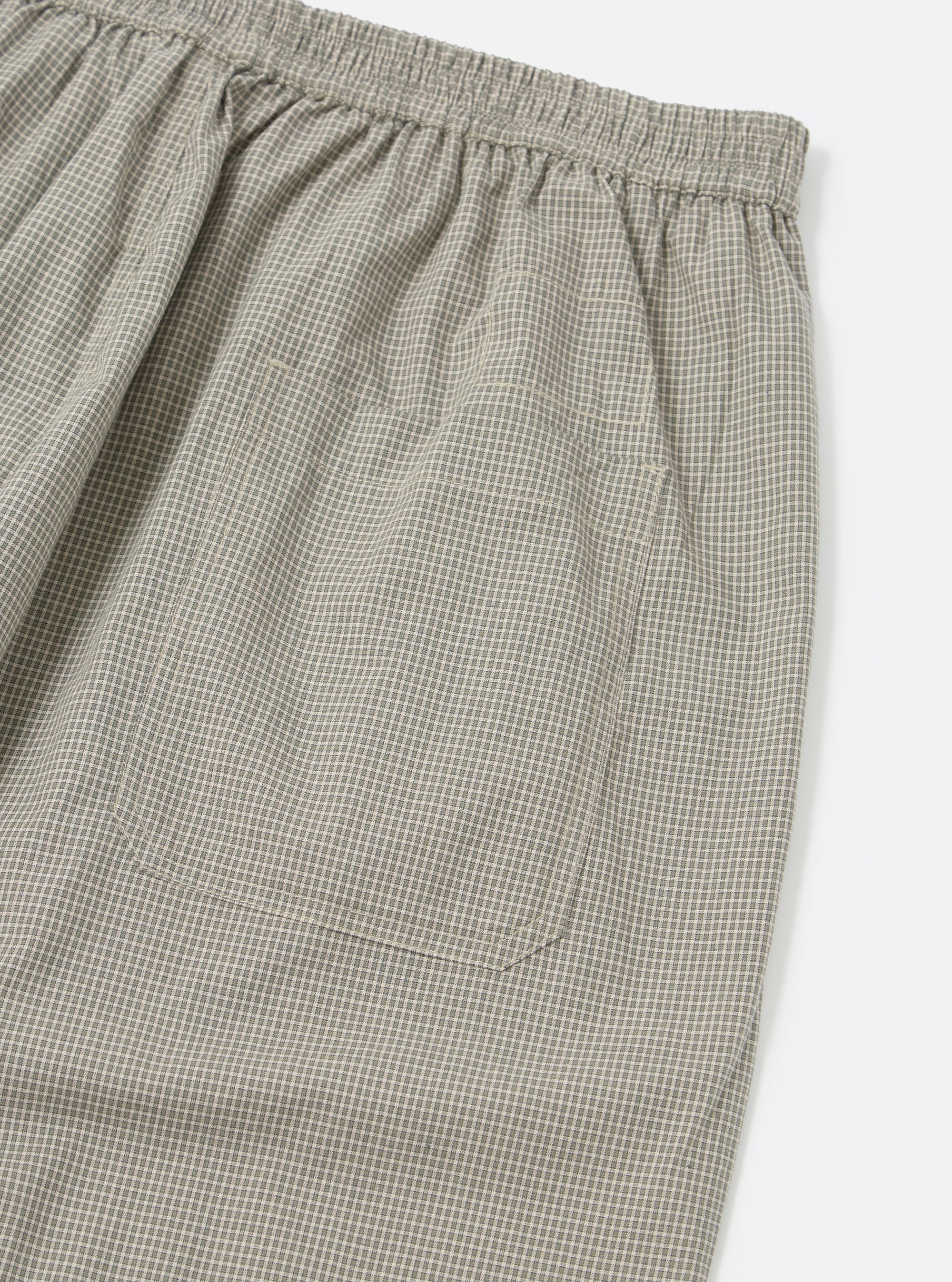 Close-up of the Green Tiny Check Pyjama Pant on a white background, showing the elastic waistband and pocket detail. The fabric has a small green and white check pattern.