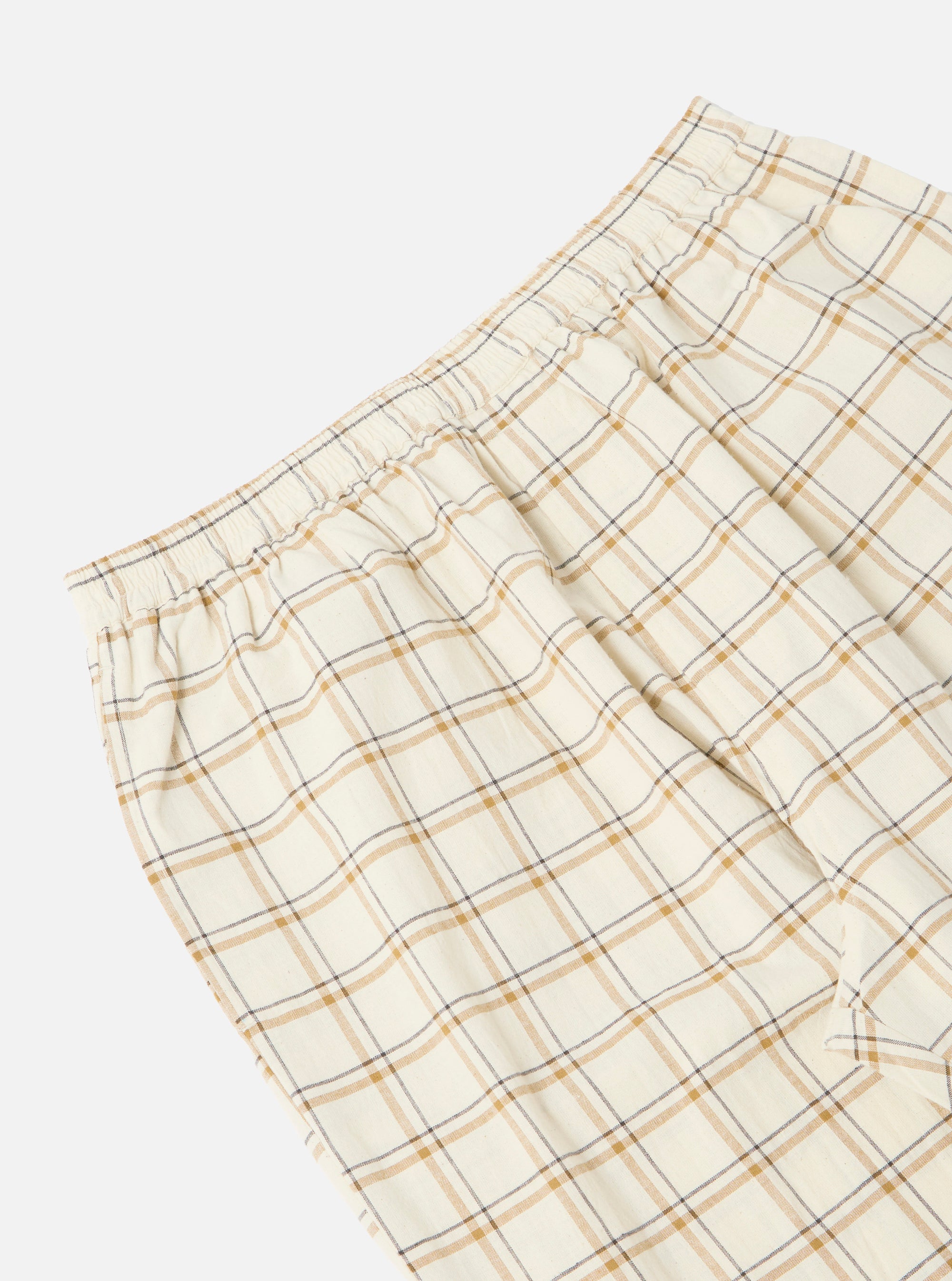 Close-up of the Ecru PJ Plaid Pyjama Pant on a white background. The plaid pattern features ecru with brown and gray lines. Elastic waistband detail.