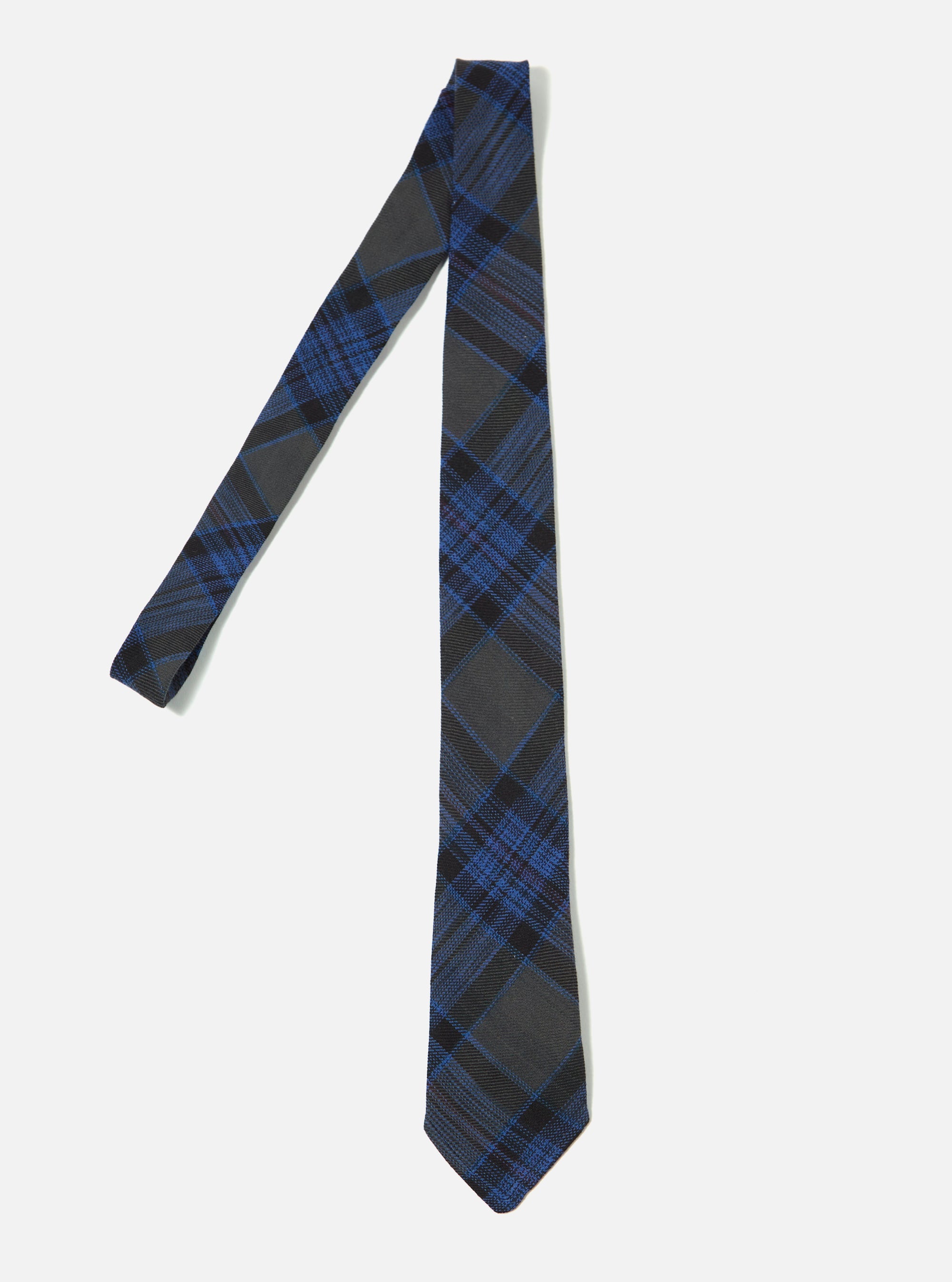 The Navy Ikat Twill Check Tie on a white background. The tie features a blue and gray plaid pattern. The fabric has a subtle texture.