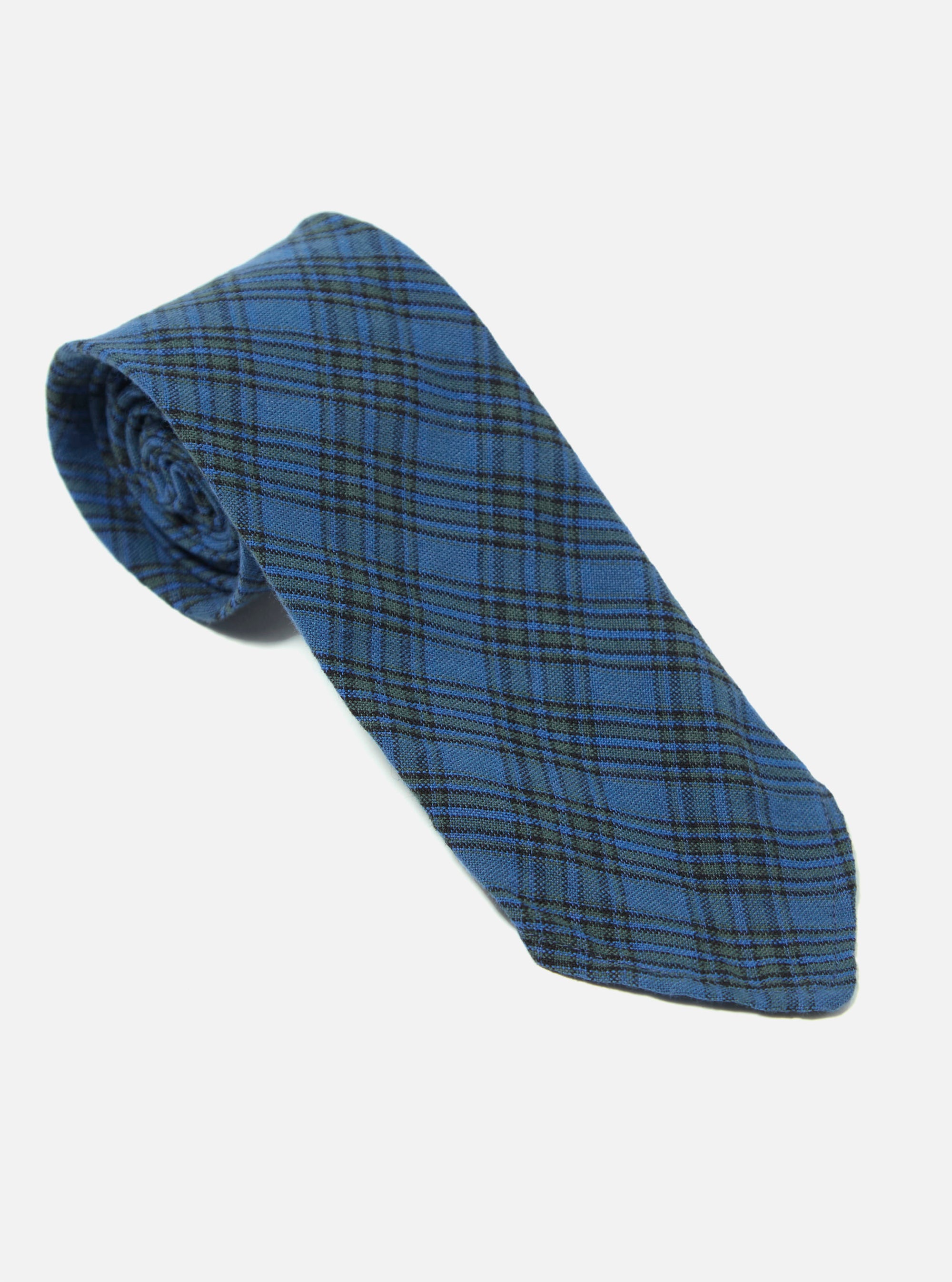 The Navy Picnic Plaid Tie, featuring a blue and green plaid pattern, is displayed on a white background. The tie is rolled up, showcasing its texture and design.