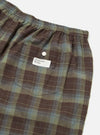 Close-up of the Green Patchwork Madras Boxer Short on a white background. The shorts feature a brown, green, and blue plaid pattern with an elastic waistband and a back pocket.