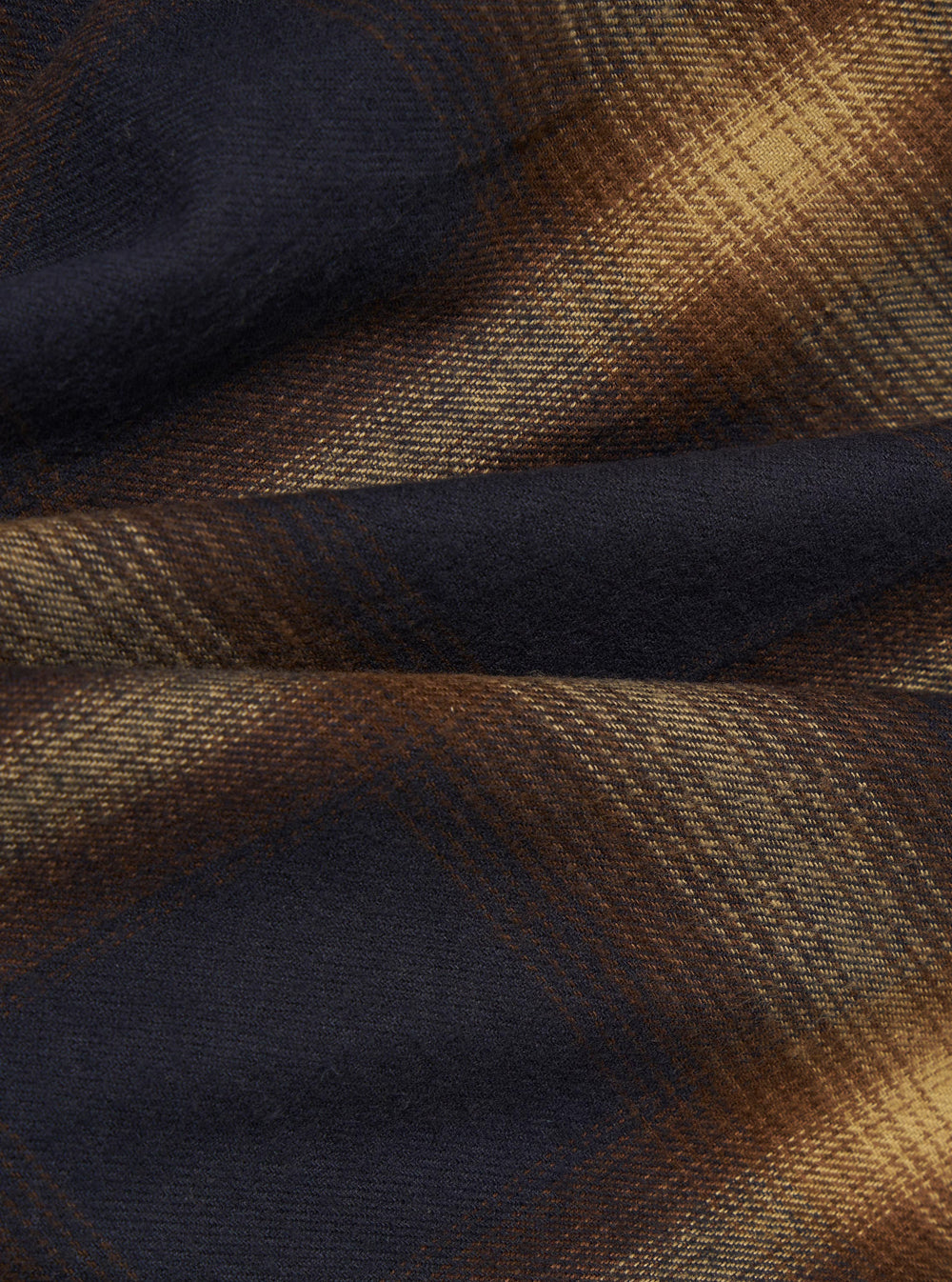 Close-up of the Navy Canyon Check Utility Shirt fabric. The shirt features a navy and canyon-colored check pattern. The material is textured. 