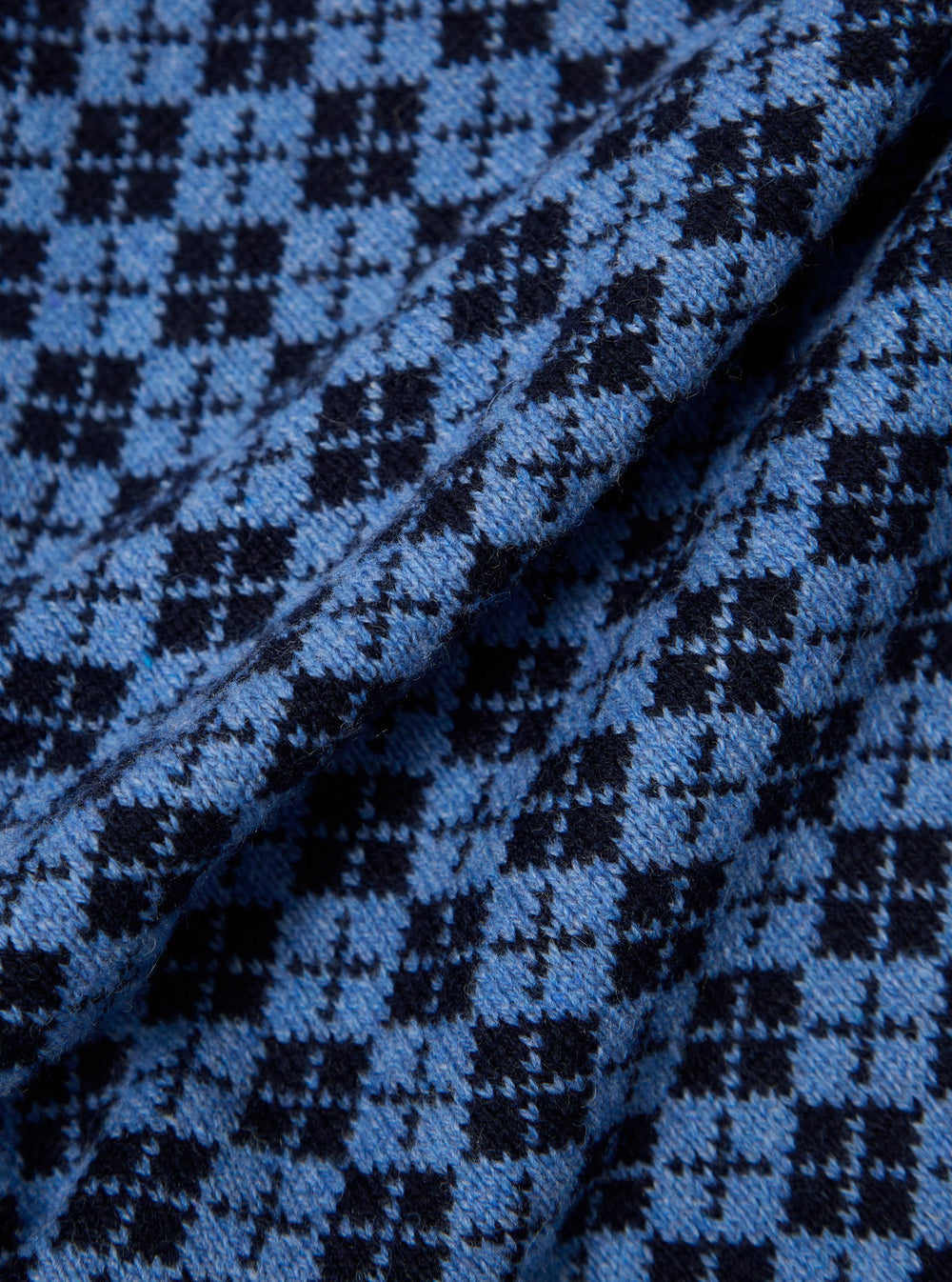 Close-up of the Pale Blue/Navy Plain Knit Argyll Allan Cardigan. The knit fabric shows a detailed argyll pattern in pale blue and navy. The texture of the knit is visible.