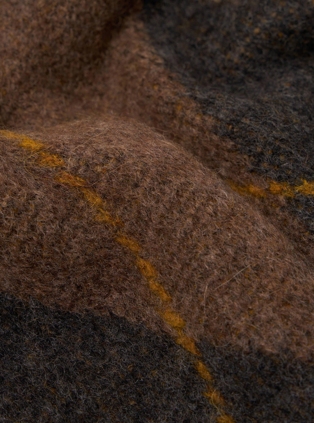 Close-up of the Brown Alpaca Knit Langdale Argyll Cardigan, showcasing the texture and pattern of the knit. The background is a simple, neutral surface.