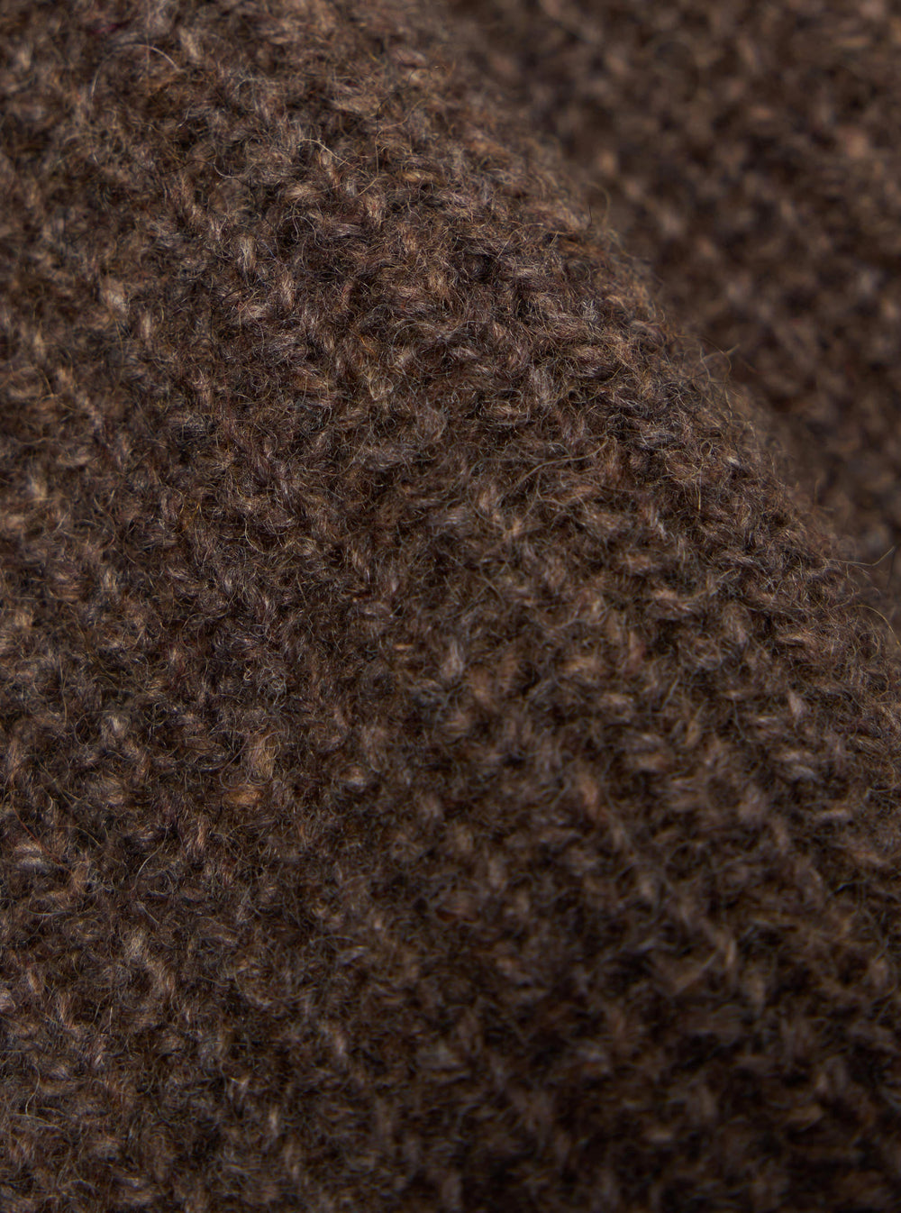 Close-up of the textured brown eco wool of a zip cardigan. The soft material is draped to show its depth and quality. Perfect for a Brown Eco Wool Zip Cardigan.