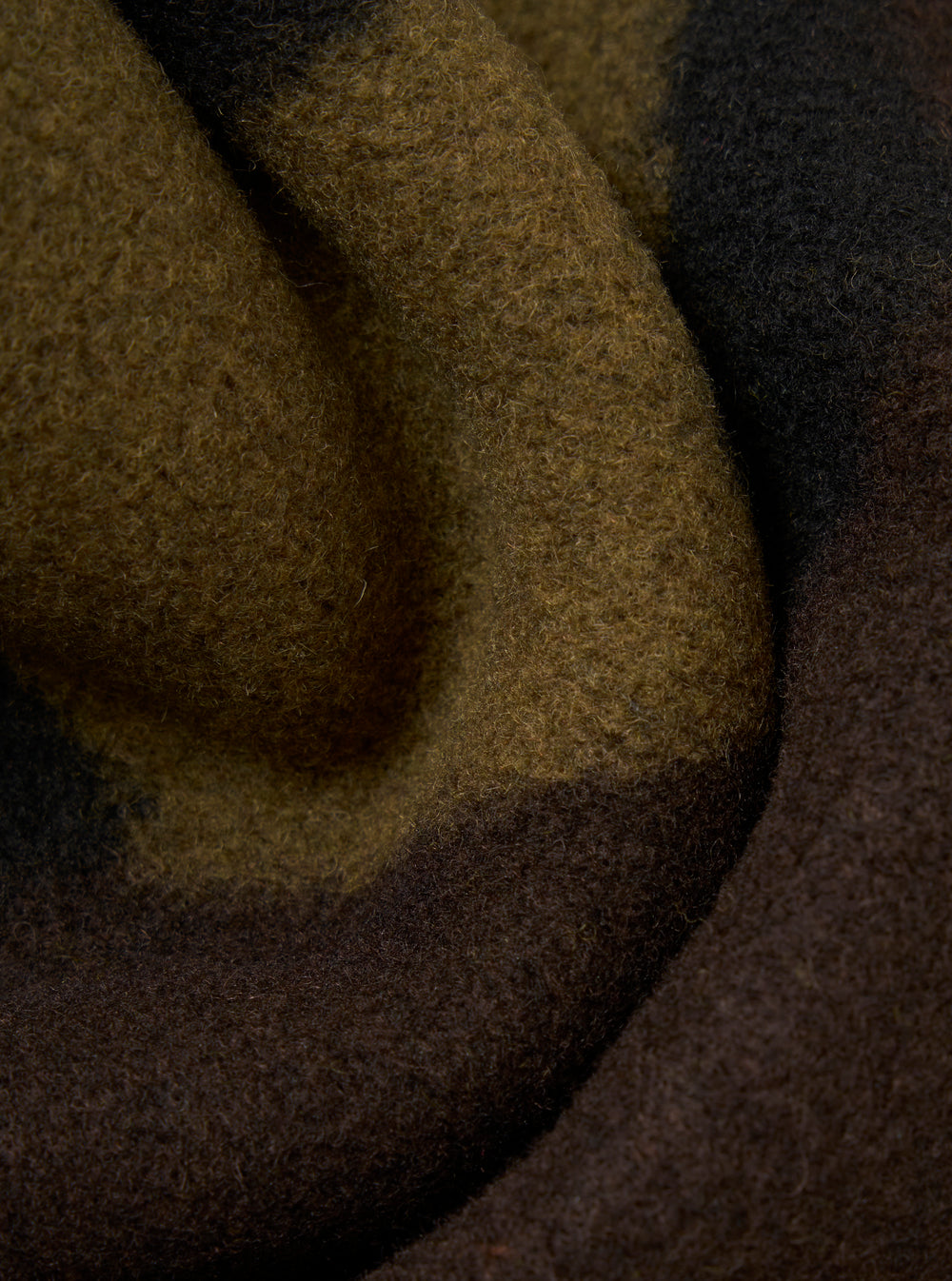 Close-up of the Camo Swede Fleece Field Jacket. The camo pattern features shades of brown, olive green, and black. The soft fleece material is draped to show texture.