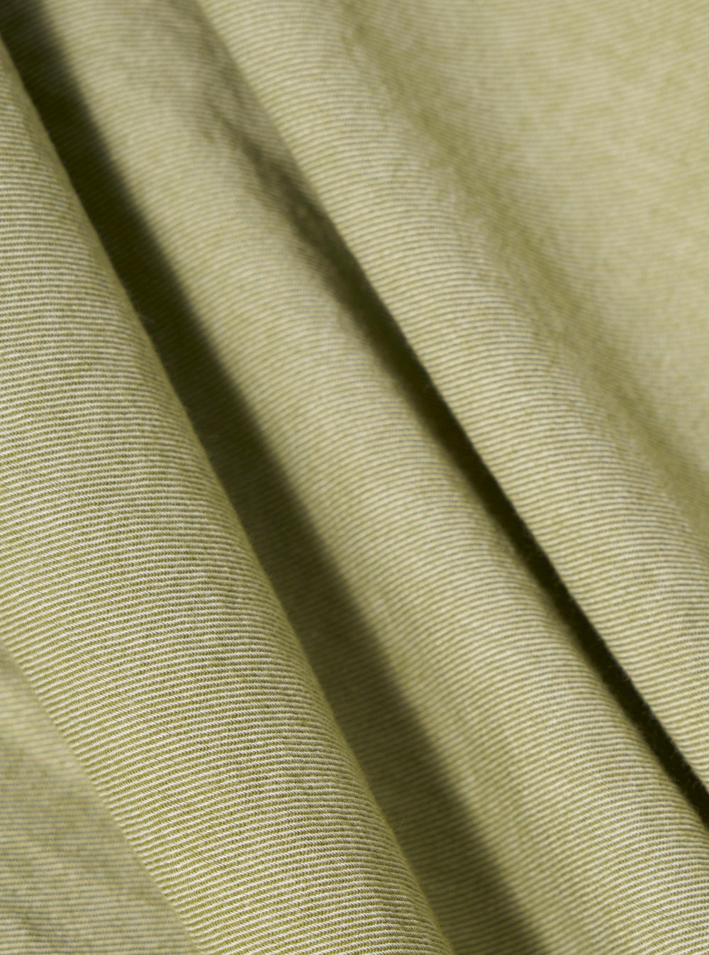 Close-up of the Green Neptune Cotton Lazy Day Shirt. Soft, light green cotton fabric with subtle stripes, draped on a flat surface. 