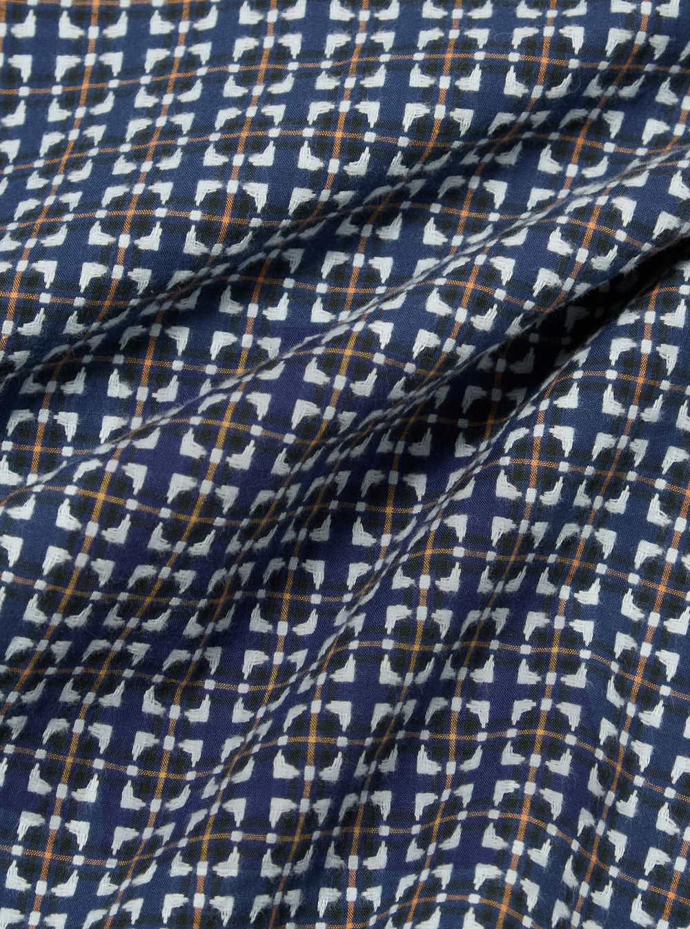 Close-up of the Navy Oscar Cotton L/S Camp Shirt fabric. The shirt features a navy background with a white, black, and orange pattern. The cotton fabric is soft and slightly wrinkled.
