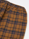Close-up of the Caramel Twill Check Pyjama Pant on a white background. The caramel, navy, and mauve check pattern is visible, along with the elastic waistband and pocket.