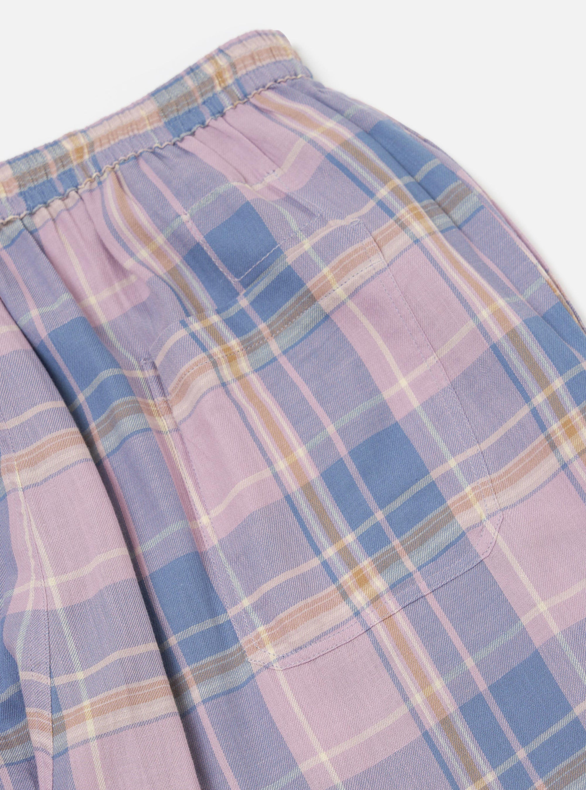 Close-up of the Pink/Blue Pastel Plaid Pyjama Pant, showcasing the elastic waistband and pocket detail. The fabric is soft and cozy, perfect for lounging. Shot on a clean, white background.
