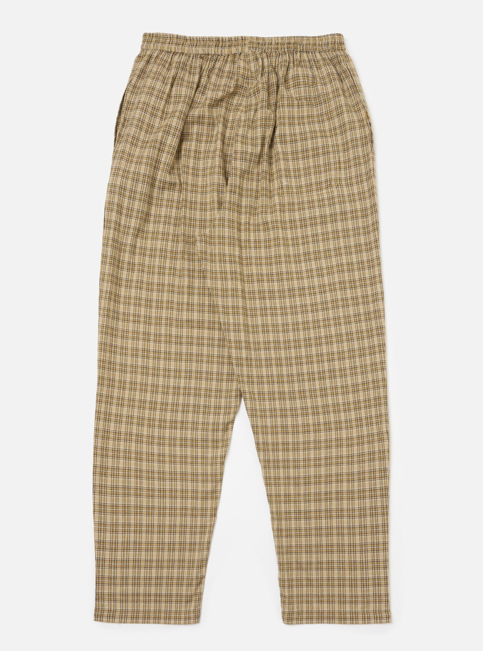 The Sand Picnic Plaid Pyjama Pant, displayed on a white background. The pants are a loose fit, made of a beige and brown plaid fabric. The pants have an elastic waistband.