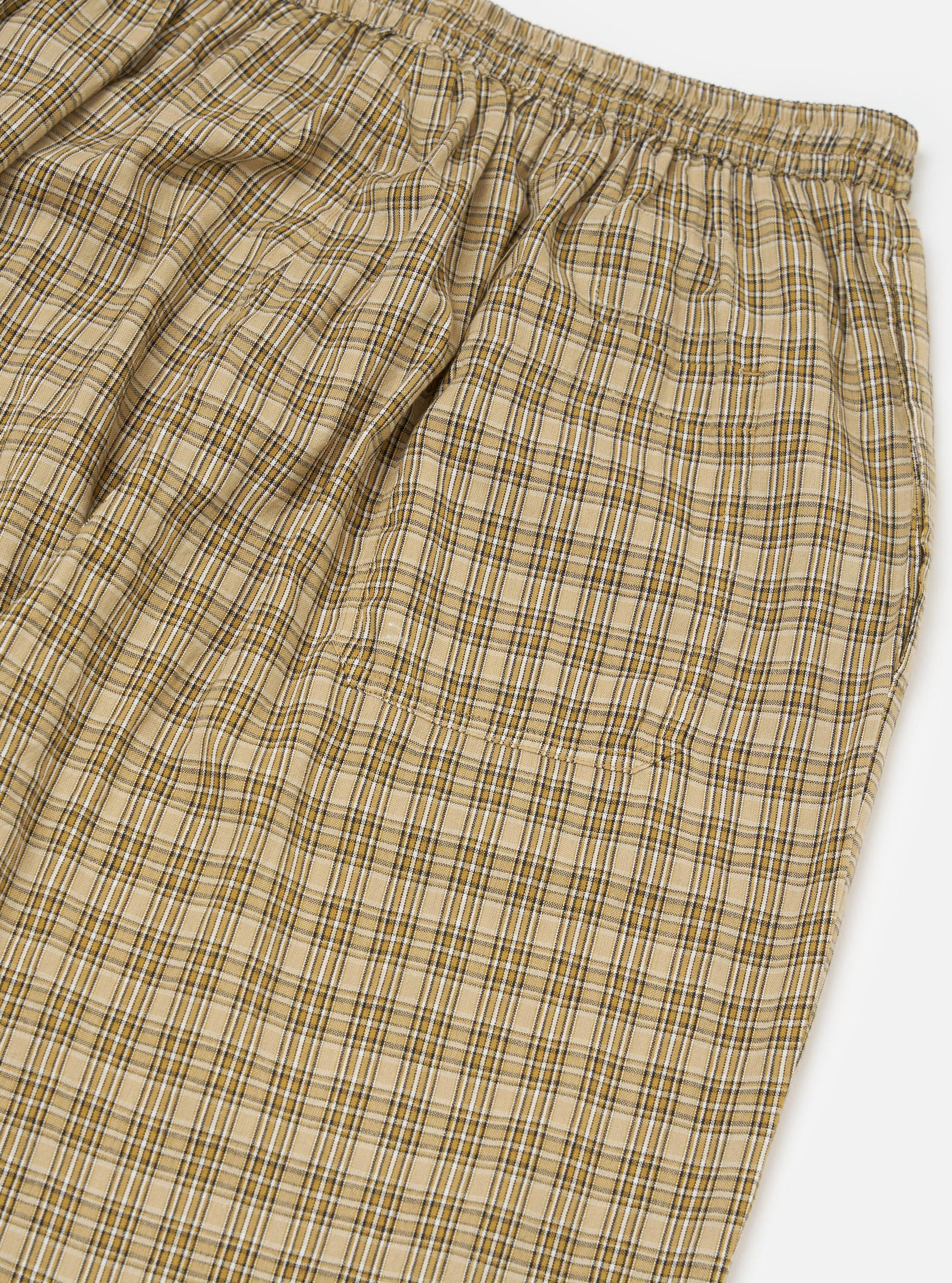 Close-up of the Sand Picnic Plaid Pyjama Pant. Features a beige, white, and brown plaid pattern. Elastic waistband. Shot on a white background.