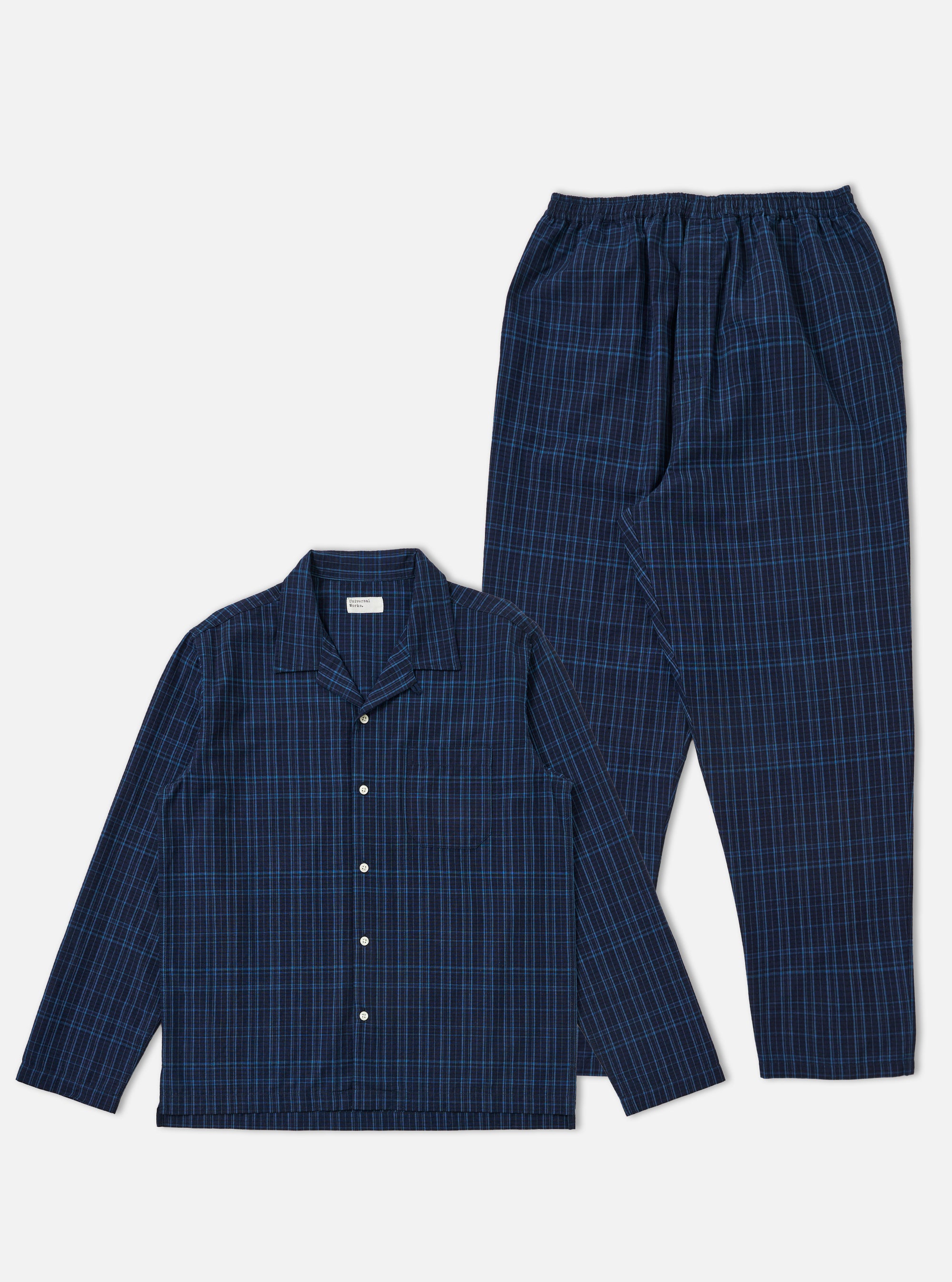 The Indigo Plaid Long Pyjama Set is laid out on a white background. The set is a dark blue plaid with long sleeves and pants.