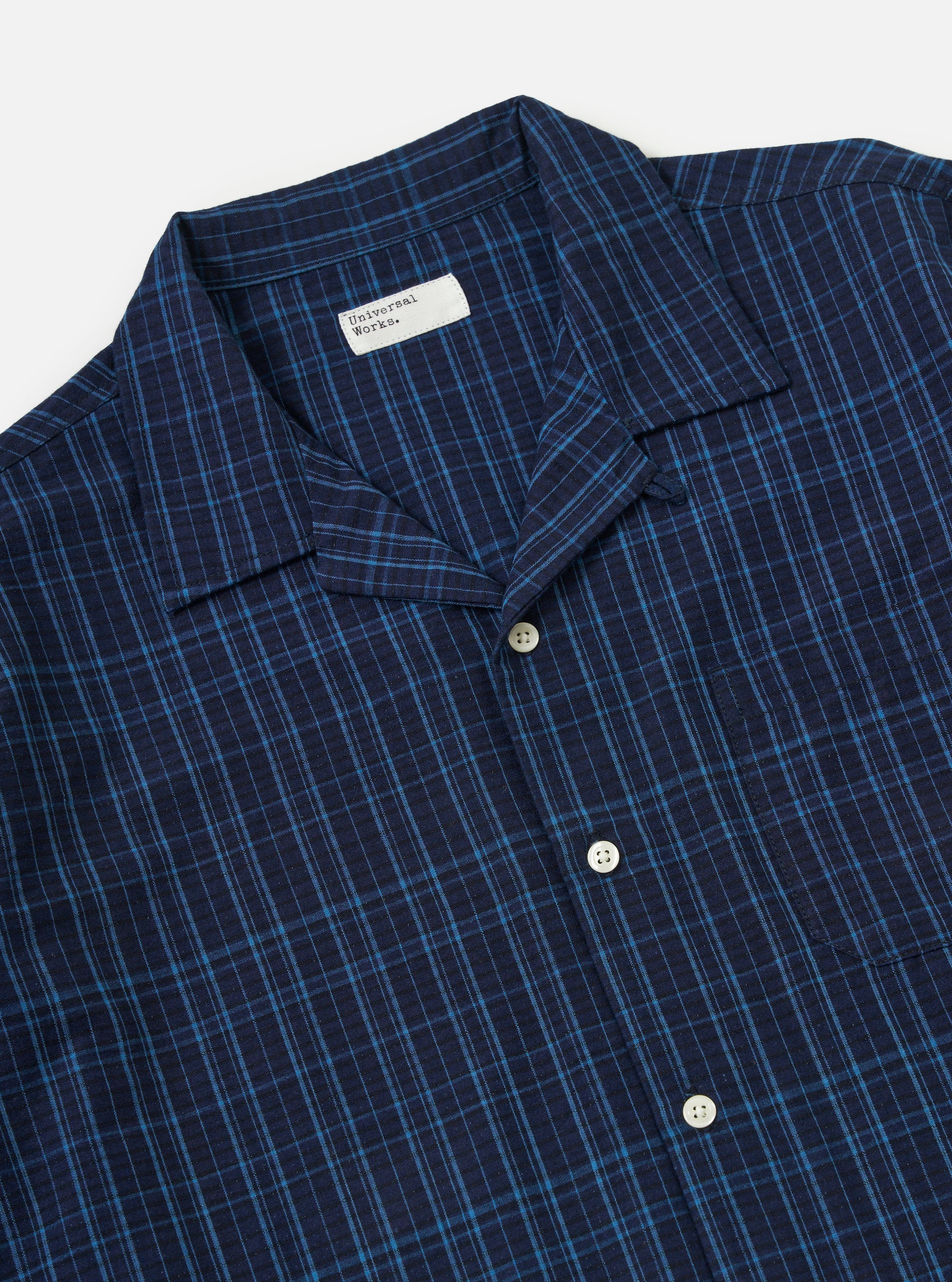 Close-up of the Indigo Plaid Long Pyjama Set top. The blue plaid shirt has white buttons and a pocket. The background is a plain white.
