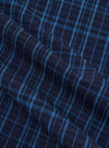 Close-up of the Indigo Plaid Long Pyjama Set fabric. The material is a soft, woven plaid in shades of indigo and light blue. The fabric is draped to show texture.