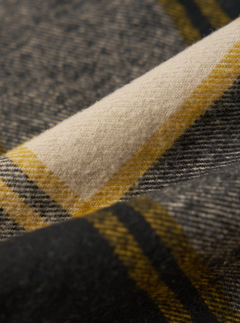 Close-up of the Black/Sand Brushed Big Check Long Pyjama Set fabric. The brushed fabric features a large check pattern in black, sand, and yellow. The material is folded to show texture.