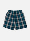 The Forest Brushed Plaid Pyjama Short, featuring a teal, navy, and white plaid pattern, elastic waist, and relaxed fit, is laid on a white surface.