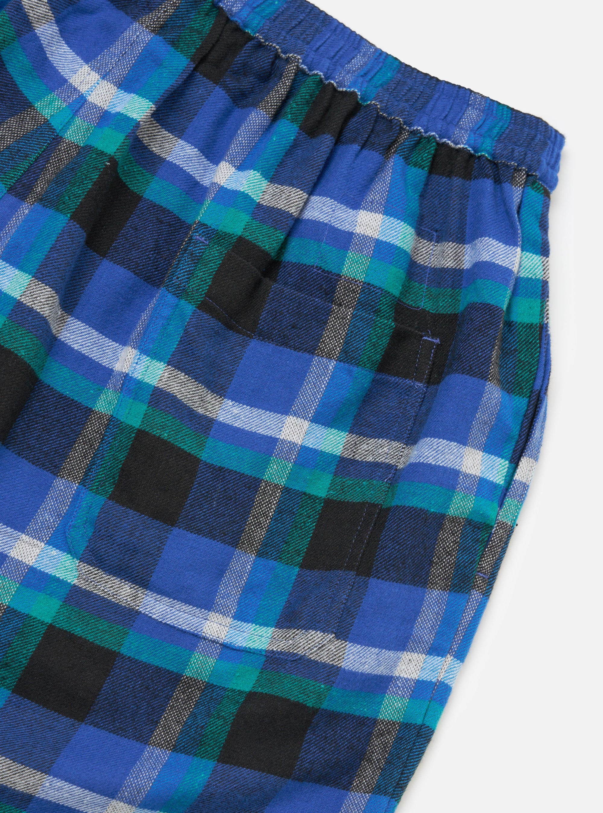 Close-up of the Blue Night Check Short Pyjama Set. Features a blue, green, black and white plaid pattern. Elastic waist. Shot on a white background.