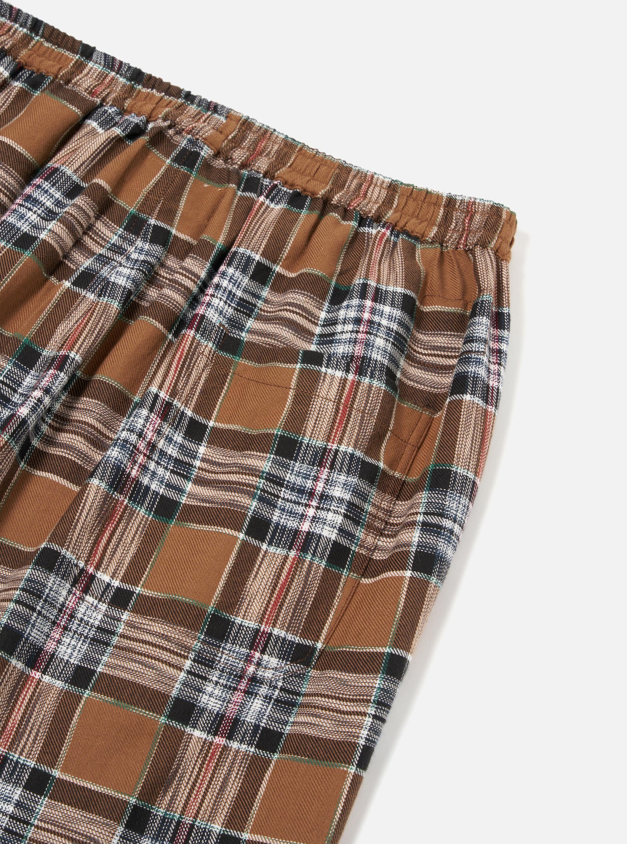 Close up of the Brown Ikat Twill Check Long Pyjama Set. The brown, black, white, red, and green plaid pants are on a white background.