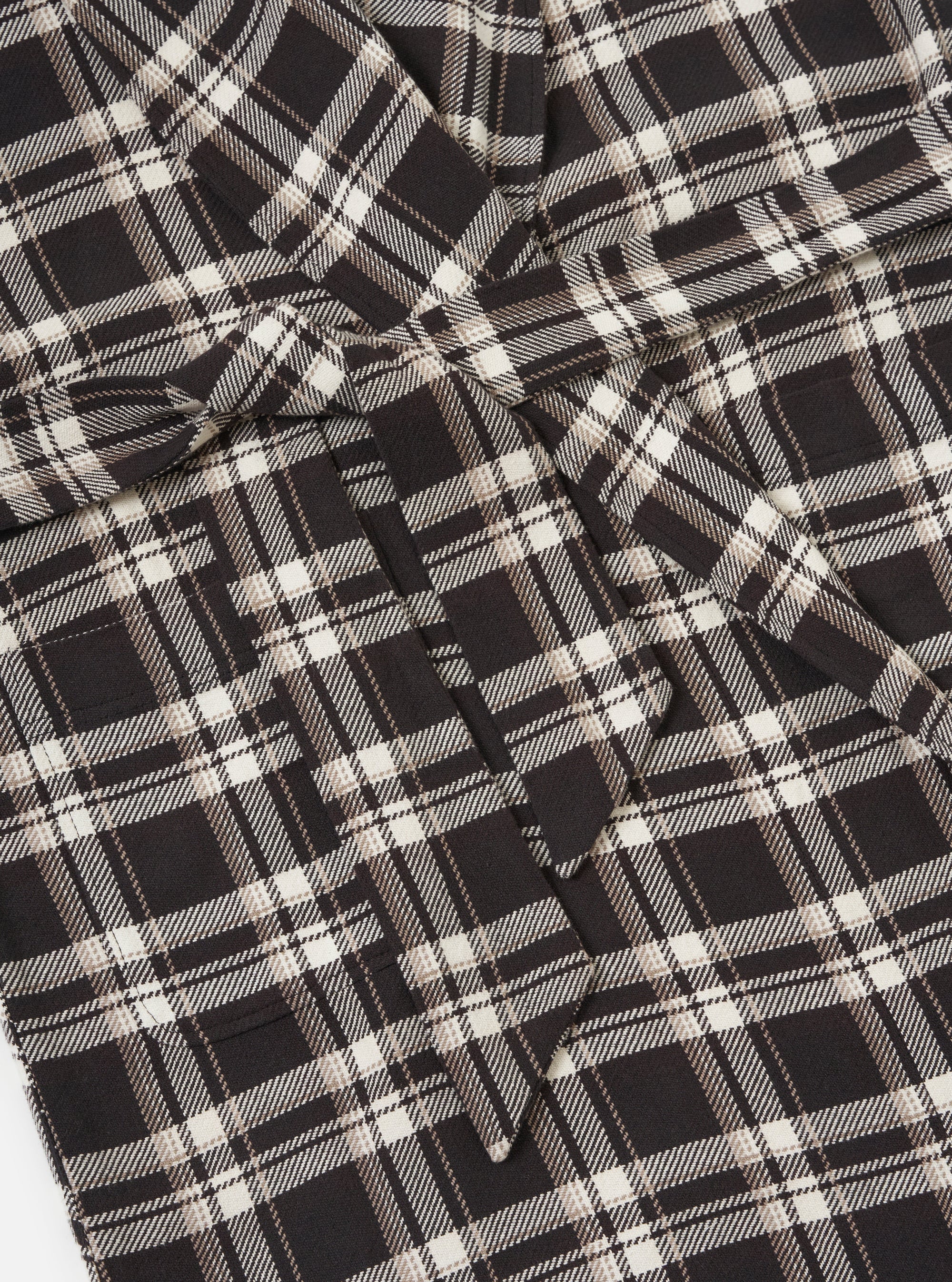 Close-up of the Black Twill Check Long Dressing Gown. The fabric is a black and white twill check. The gown is laid flat on a white surface.