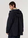 A model is wearing the Navy Seo Recycled Nylon Boston Parka, shown from a three-quarter rear angle against a plain white background. The parka features a longline silhouette, a large adjustable hood, and a clean back panel with a central vertical seam. The navy blue recycled nylon fabric has a smooth, technical appearance, and the model is wearing the hood up.