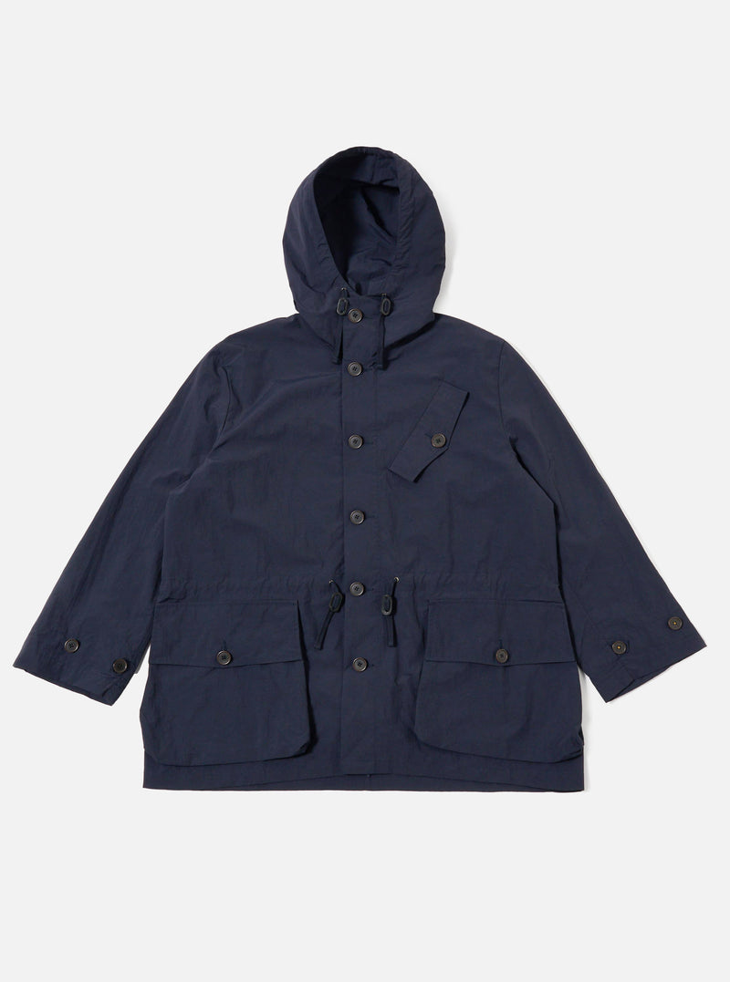 The Navy Seo Recycled Nylon Boston Parka is shown as a flat lay against a plain white background. The parka features a large adjustable hood, a full-length front zipper concealed by a buttoned placket, and two large 3D patch pockets at the hips. The lightweight, dark navy nylon fabric has a crisp texture, and the garment is designed with a relaxed, oversized fit.