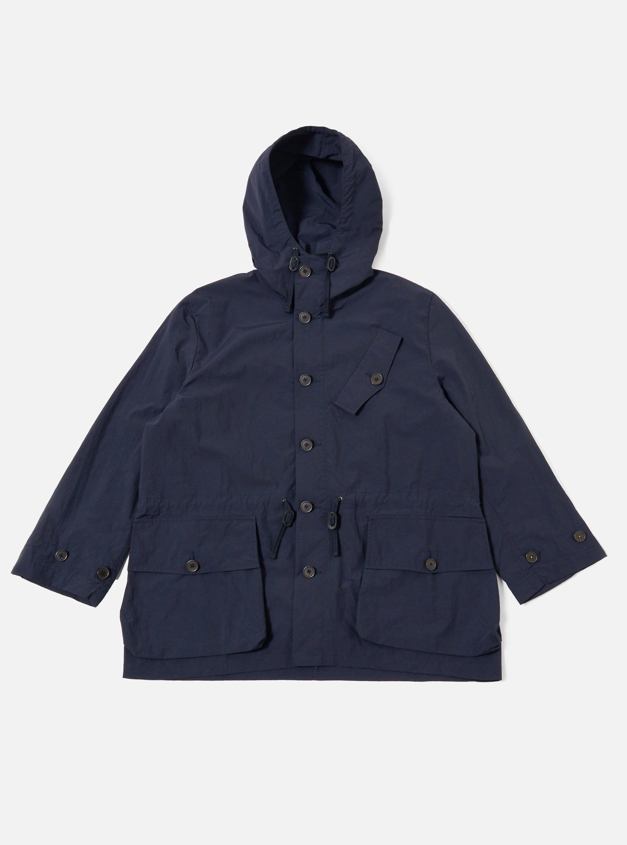 The Navy Seo Recycled Nylon Boston Parka is shown as a flat lay against a plain white background. The parka features a large adjustable hood, a full-length front zipper concealed by a buttoned placket, and two large 3D patch pockets at the hips. The lightweight, dark navy nylon fabric has a crisp texture, and the garment is designed with a relaxed, oversized fit.