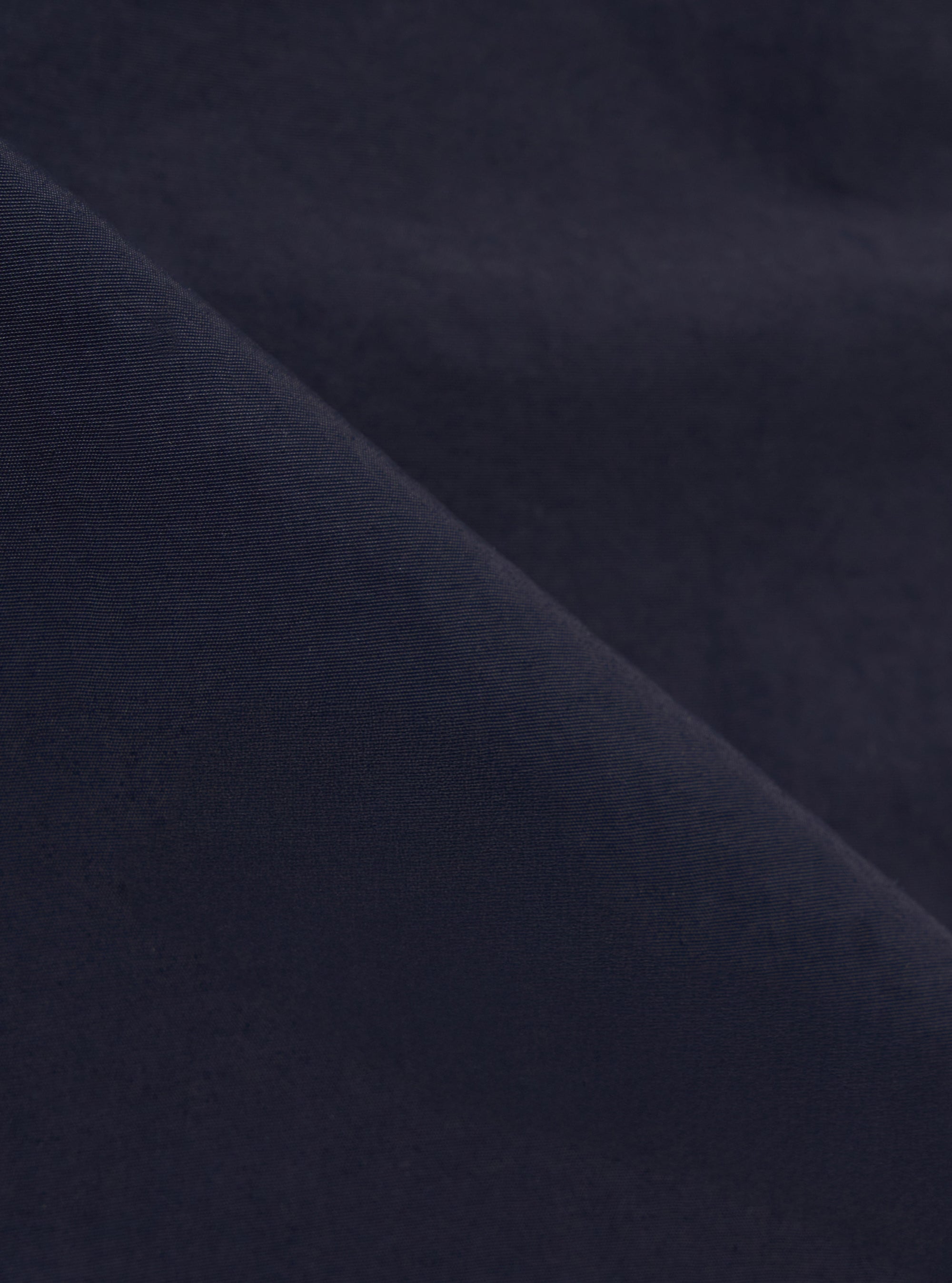A close-up fabric swatch of the Navy Seo Recycled Nylon Boston Parka highlights the deep navy blue color and the lightweight, tightly woven texture of the recycled nylon material.