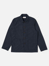 The Navy Recycled Polytech Bakers Jacket is displayed as a flat lay against a white background. The jacket features a five-button front closure with a signature angled buttonhole at the center, a classic collar, and four front patch pockets: one on the chest and three on the lower portion of the garment. The jacket is finished with a curved front hem and visible tonal stitching.