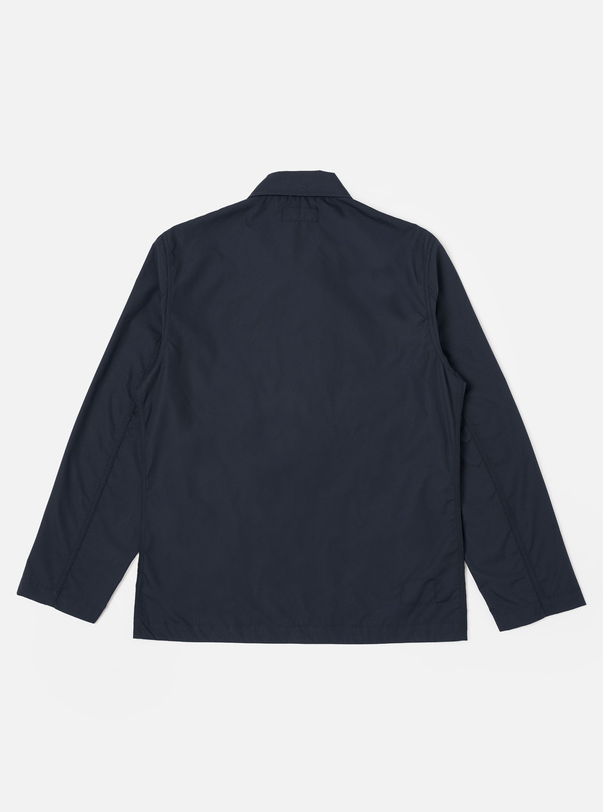The Navy Recycled Polytech Bakers Jacket is shown from the back as a flat lay against a plain white background. The image highlights the clean construction, simple collar, and straight hem of the jacket.
