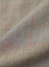 A close-up fabric swatch of the Grey Brown Wales Glen Check Barra Jacket highlights the classic Prince of Wales check pattern. The intricate weave features a mix of grey, brown, and black threads, creating a textured and sophisticated geometric design.