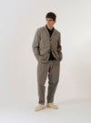 The Grey Brown Wales Glen Check Barra Jacket is shown as a flat lay against a white background. The jacket features a brown and grey Glen check pattern, a three-button front closure, a notched lapel, and two large patch pockets at the waist.