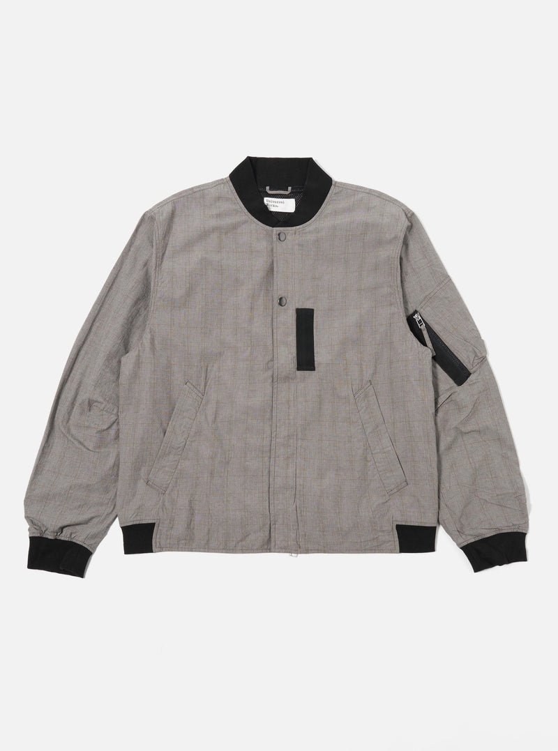 The Grey Brown Wales Glen Check NS Bomber Jacket is shown as a flat lay against a plain white background. The jacket features a prominent glen check pattern in shades of grey and brown, a full zip front, and a classic ribbed collar, cuffs, and hem. Two slanted welt pockets are visible on the front.