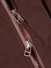 The Brown Peached Poplin NS Bomber Jacket is shown from the back as a flat lay against a plain white background. The image highlights the clean, simple construction of the garment's rear panel, featuring a ribbed collar and set-in sleeves. The peached cotton poplin fabric has a smooth, matte brown finish.