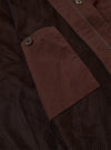 The Brown Peached Poplin NS Bomber Jacket is shown as a flat lay against a plain white background. The jacket features a ribbed collar, a full-length central zipper, and two large slanted patch pockets at the waist. The cotton poplin fabric has a smooth, matte brown finish.