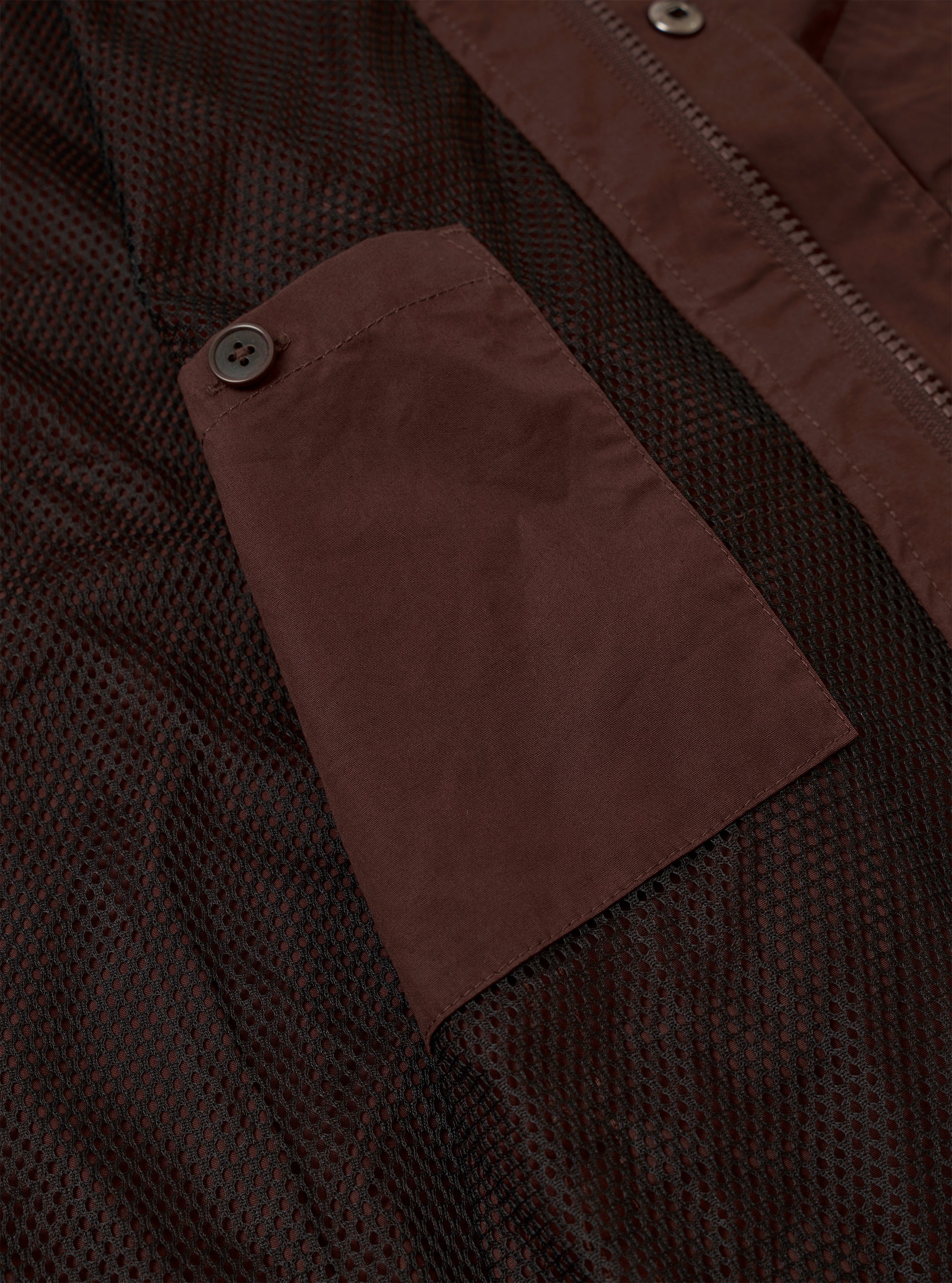 The Brown Peached Poplin NS Bomber Jacket is shown as a flat lay against a plain white background. The jacket features a ribbed collar, a full-length central zipper, and two large slanted patch pockets at the waist. The cotton poplin fabric has a smooth, matte brown finish.