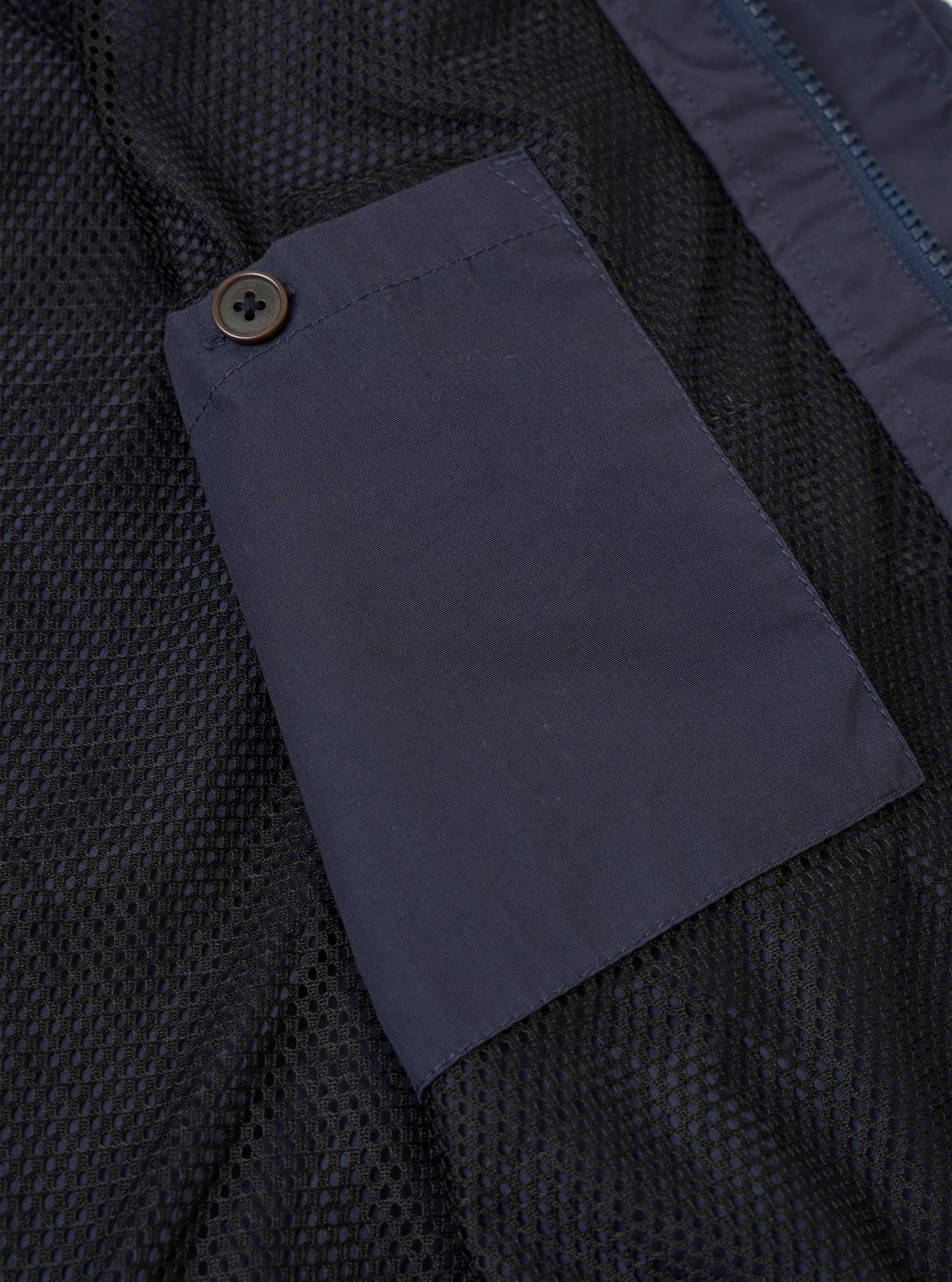 The Navy Peached Poplin NS Bomber Jacket is shown as a flat lay against a plain white background. This detail view highlights the jacket's interior, featuring a mesh aertex lining and an internal buttoned chest pocket. The dark navy cotton poplin fabric and the ribbed collar with a contrast stripe are clearly visible.