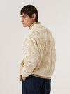 A model wears the Ecru 3D Flower NS Bomber Jacket against a plain white background, shown from a rear three-quarter angle. The jacket features an intricate 3D floral texture throughout the ecru fabric and a classic bomber silhouette with a ribbed collar, cuffs, and hem. The model is shown from the waist up.