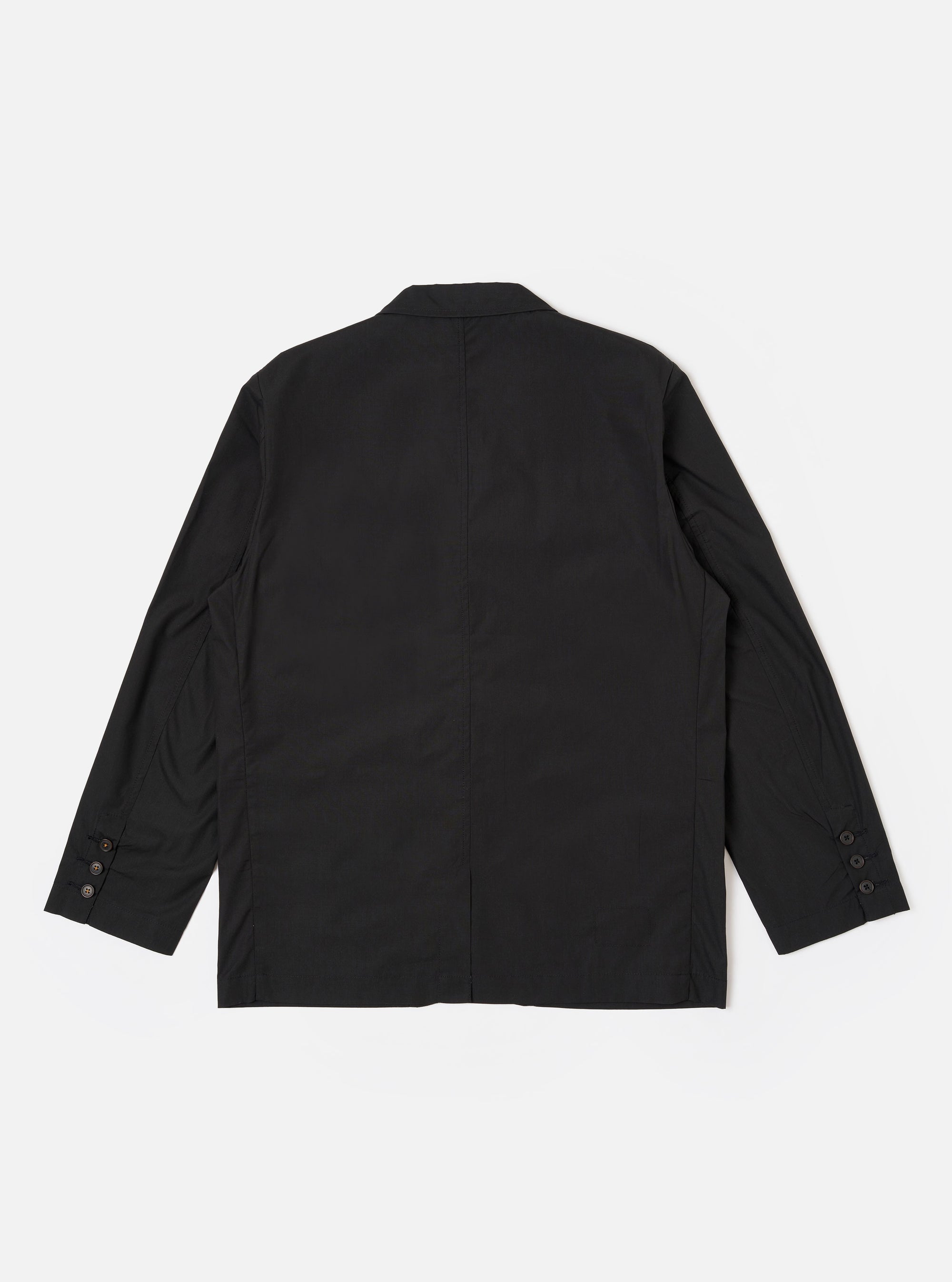 The Black Recycled Polytech Capitol Jacket is shown from the back as a flat lay against a plain white background. The image highlights the smooth black fabric, a single rear vent at the hem, and the clean construction of the shoulders and sleeves.