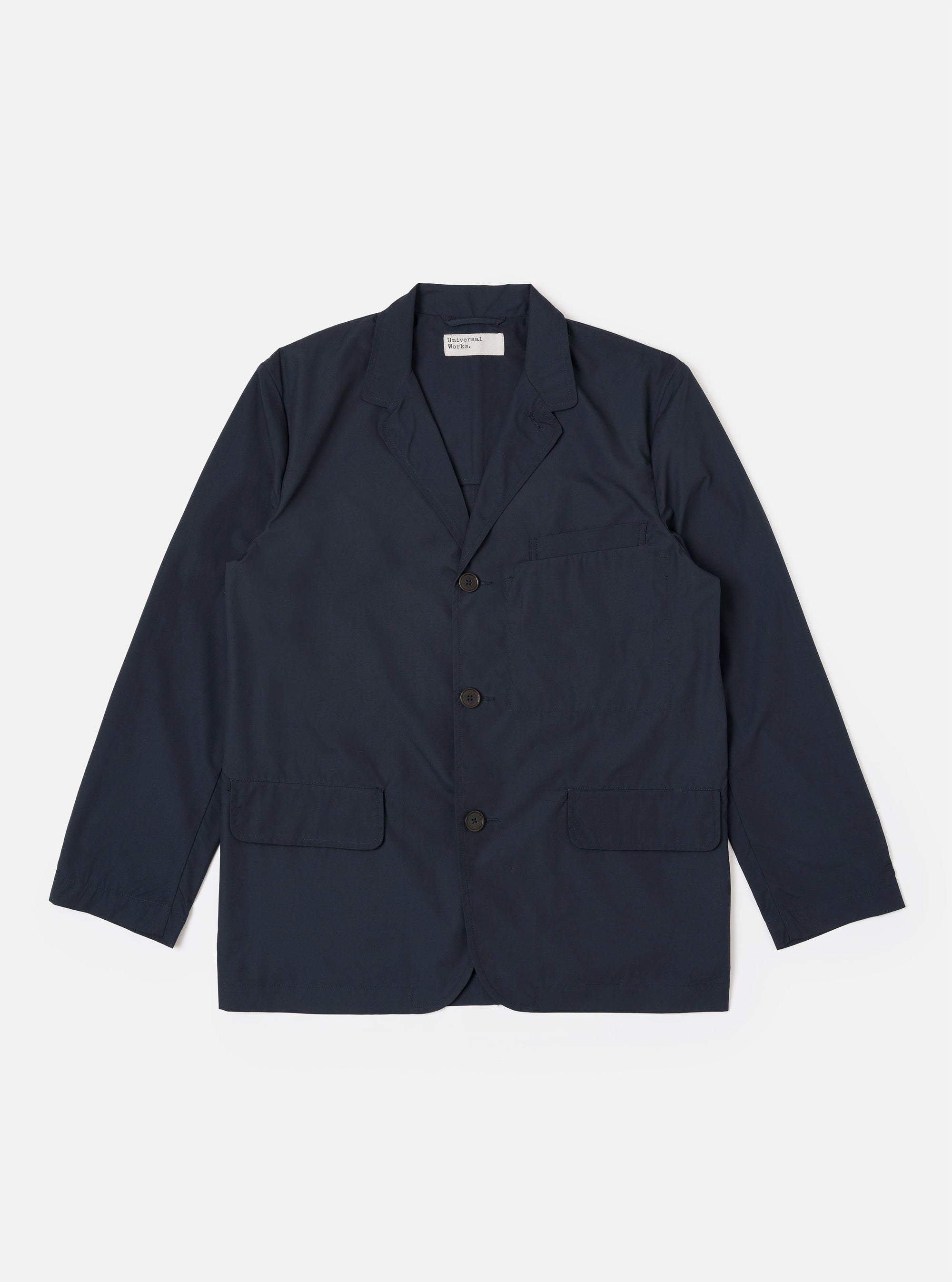 The Navy Recycled Polytech Capitol Jacket is shown as a flat lay against a plain white background. The jacket features a notched lapel, a three-button front closure, a single chest pocket, and two large patch pockets at the waist. The fabric is a deep navy blue with a smooth finish.