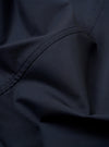 The Navy Recycled Polytech Capitol Jacket is shown from the back as a flat lay against a plain white background. The image highlights the clean construction of the shoulders, the straight hem, and the smooth texture of the recycled fabric.