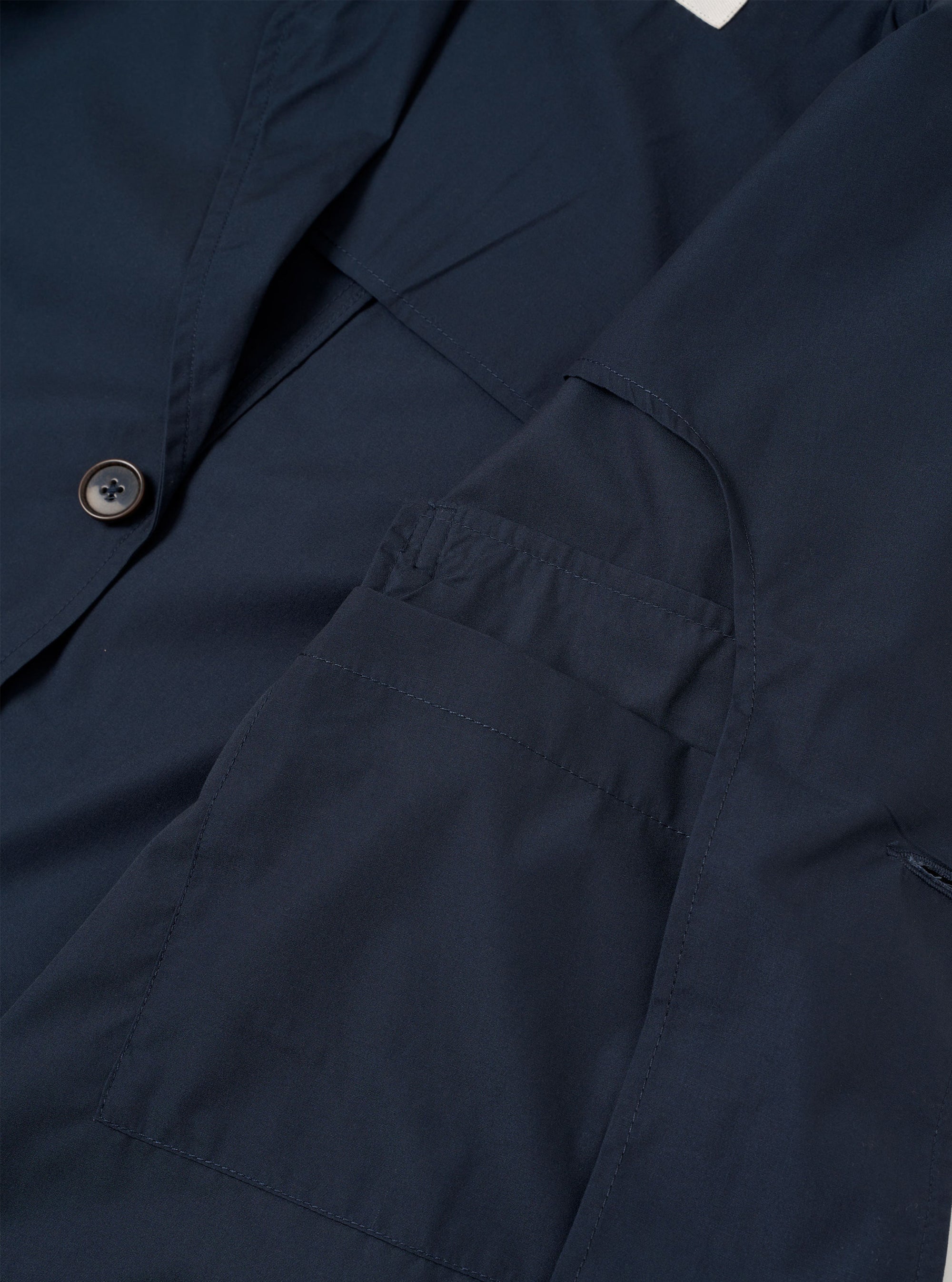 The Navy Recycled Polytech Capitol Jacket is shown from the back as a flat lay against a plain white background. The image highlights the clean construction of the shoulders, the straight hem, and the smooth texture of the recycled polytech fabric.