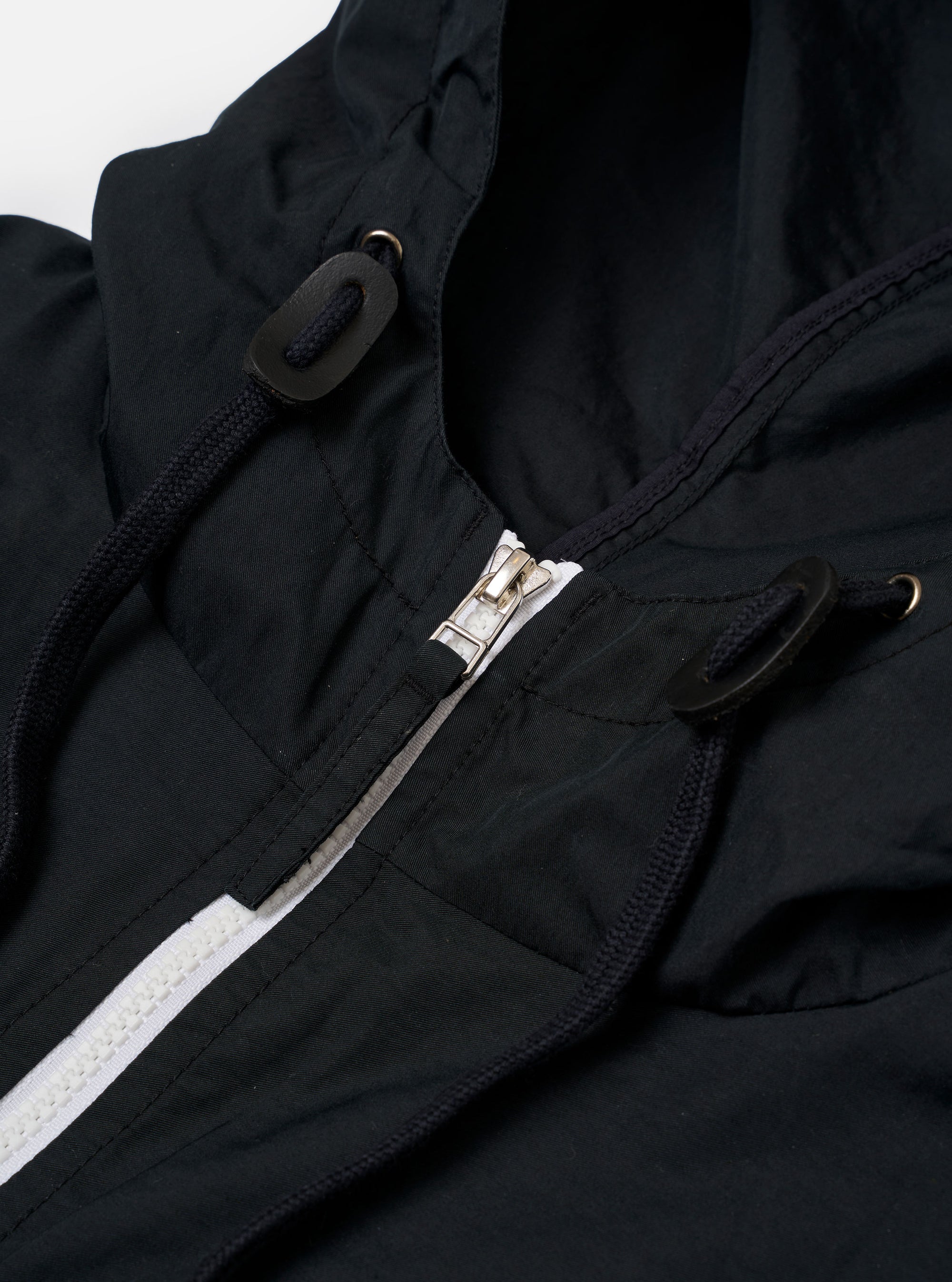The Navy Cotton Recycled Nylon Mix Daley Jacket is presented as a flat lay against a plain white background. The image shows the back of the navy blue jacket, highlighting the hood, straight hem, and the functional construction of the cotton and recycled nylon blend fabric.