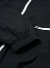 The Navy Cotton Recycled Nylon Mix Daley Jacket is shown in a detail view as a flat lay against a plain white background. This close-up highlights the lower portion of the jacket, featuring a zipped hand warmer pocket and the structured hemline. The fabric has a smooth, matte finish.