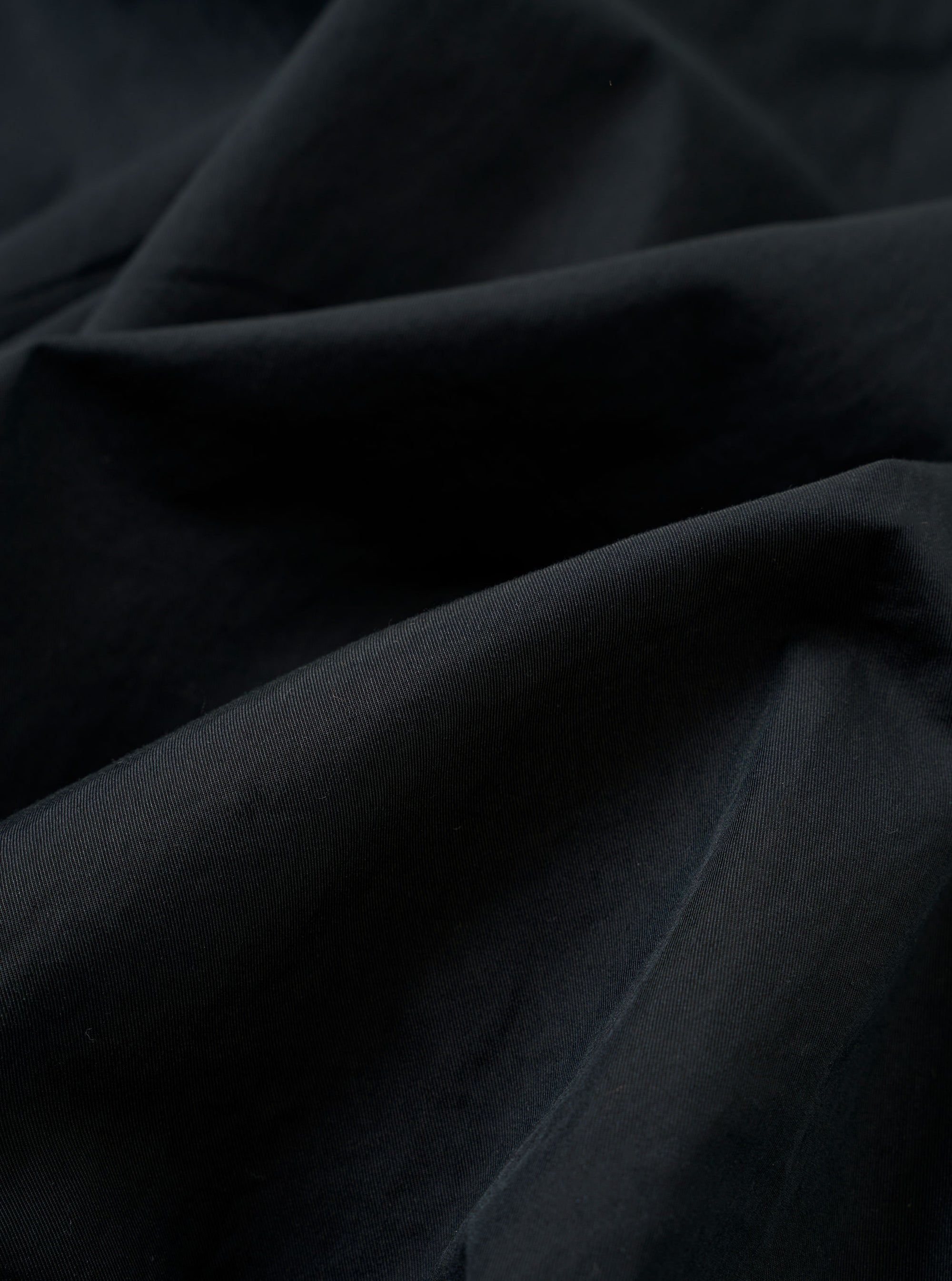 The Navy Cotton Recycled Nylon Mix Daley Jacket is shown in a detail view as a flat lay against a white background. This close-up highlights the adjustable drawstring hood, the top of the zipper closure, and the crisp texture of the navy blue cotton-nylon blend fabric.