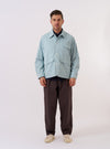 The Aqua Organic Fine Cord Duty Jacket is shown as a flat lay against a plain white background. The jacket features a classic collar, a button-up front, and four large patch pockets on the front. The fine-ribbed corduroy texture of the organic cotton fabric is visible.