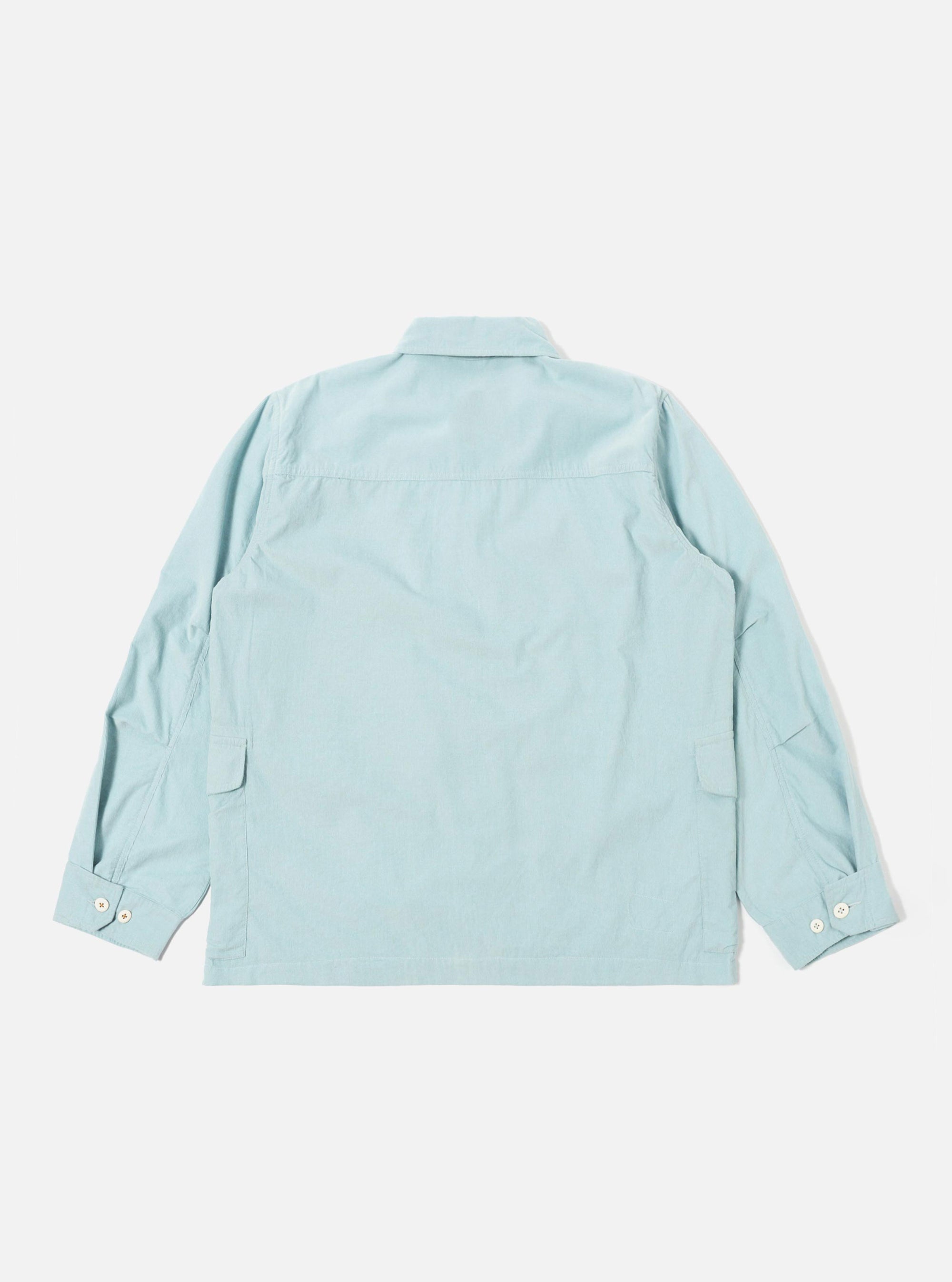 The Aqua Organic Fine Cord Duty Jacket is shown from the back as a flat lay against a plain white background. The image highlights the clean construction of the jacket, featuring a straight hem, a central seam, and a simple collar. The fine corduroy texture is visible across the light blue fabric.
