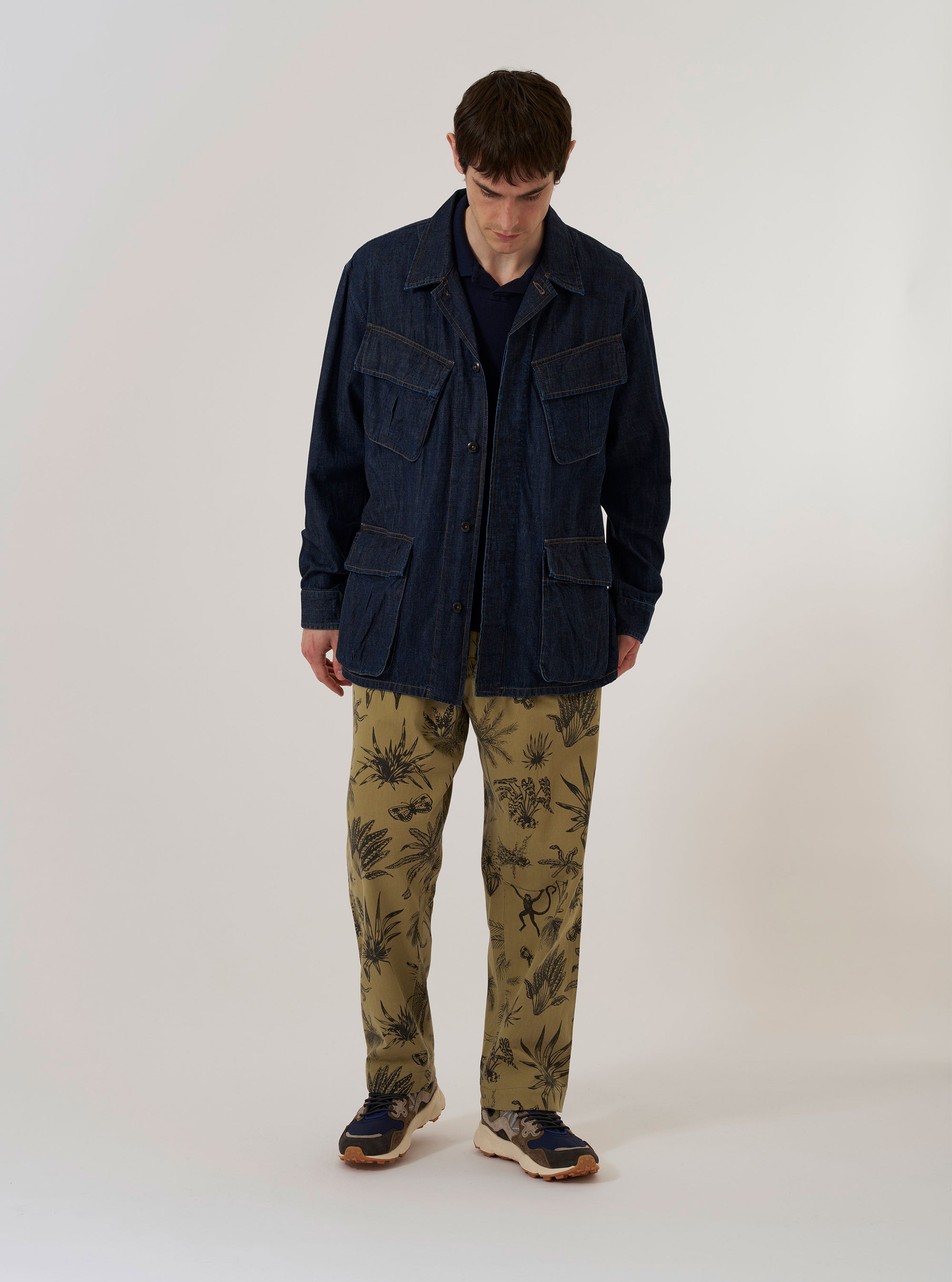 The Indigo Kaihara LT WT Denim Jungle Jacket is shown as a flat lay against a plain white background. This lightweight indigo-dyed denim jacket features a camp collar, a concealed button front placket, and four prominent front patch pockets with buttoned flaps. The design includes two angled chest pockets and two larger bellowed waist pockets.