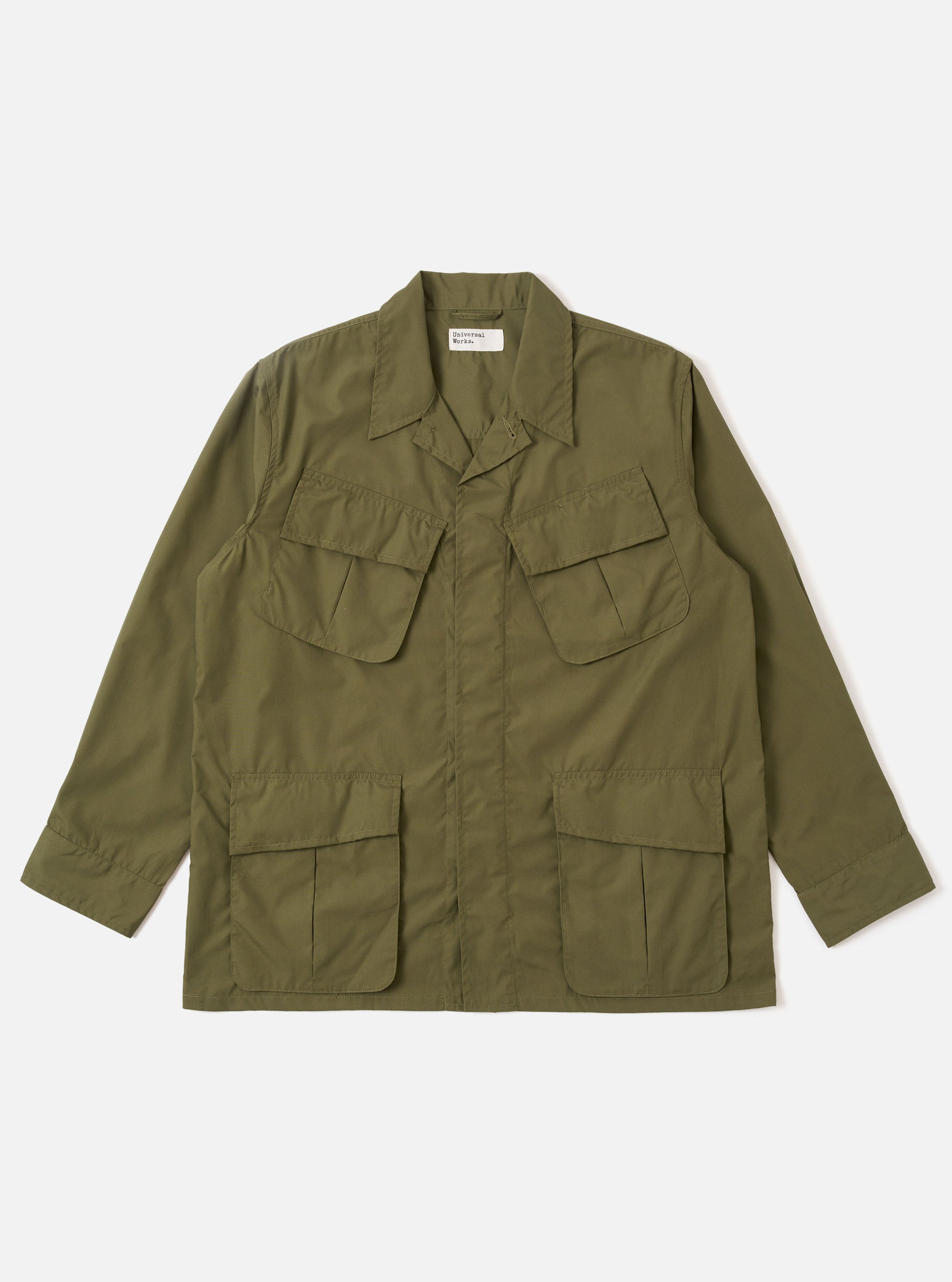 The Olive Recycled Polytech Jungle Jacket is shown as a flat lay against a plain white background. The jacket features a concealed button front placket and four large, 3D pleated pockets with concealed button-down flaps on the front. It has a structured collar and adjustable cuffs.